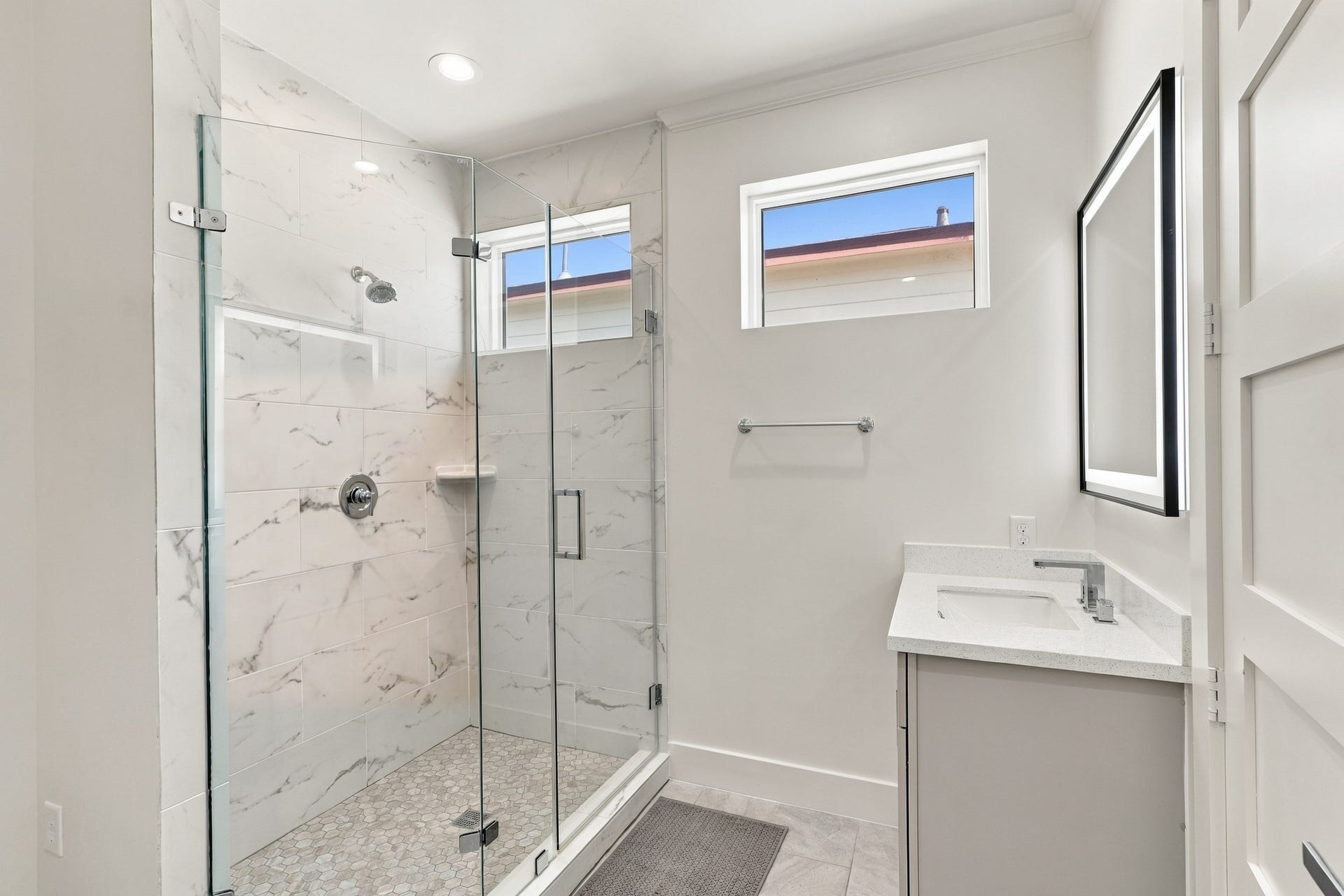 17211 Termini San Luis Pass Rd, Galveston, TX 77554 Full bathroom, alternate view
Natural light enters through high windows in this thoughtfully finished bathroom. A glass-enclosed shower with marble-look tile, mosaic flooring, and a coordinating vanity creates a cohesive coastal look.