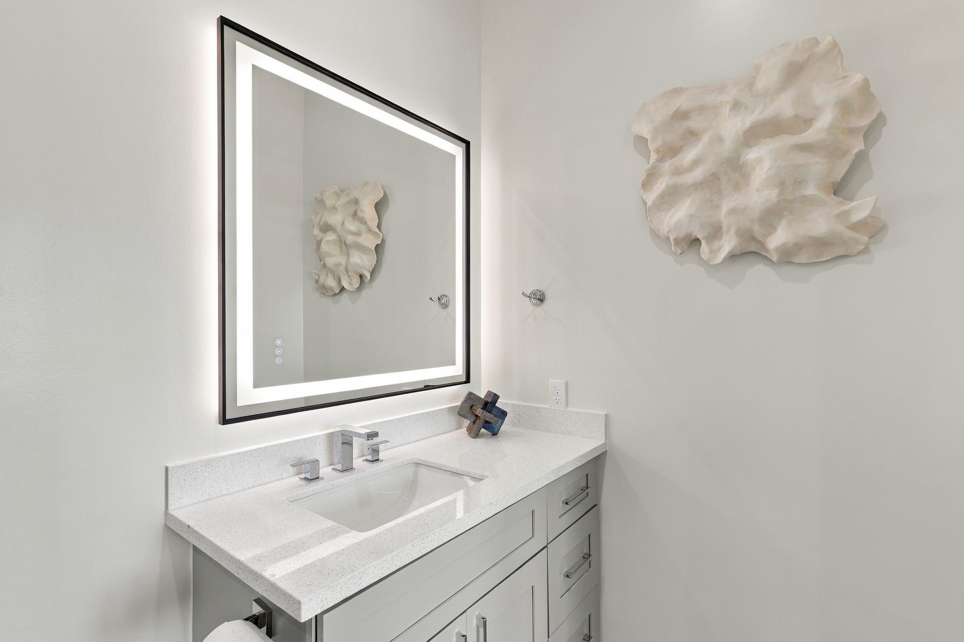 17211 Termini San Luis Pass Rd, Galveston, TX 77554 Bathroom vanity detail
A softly illuminated mirror and chrome fixtures complement the light countertop and gray cabinetry. Generous vanity storage keeps the space both practical and refined.