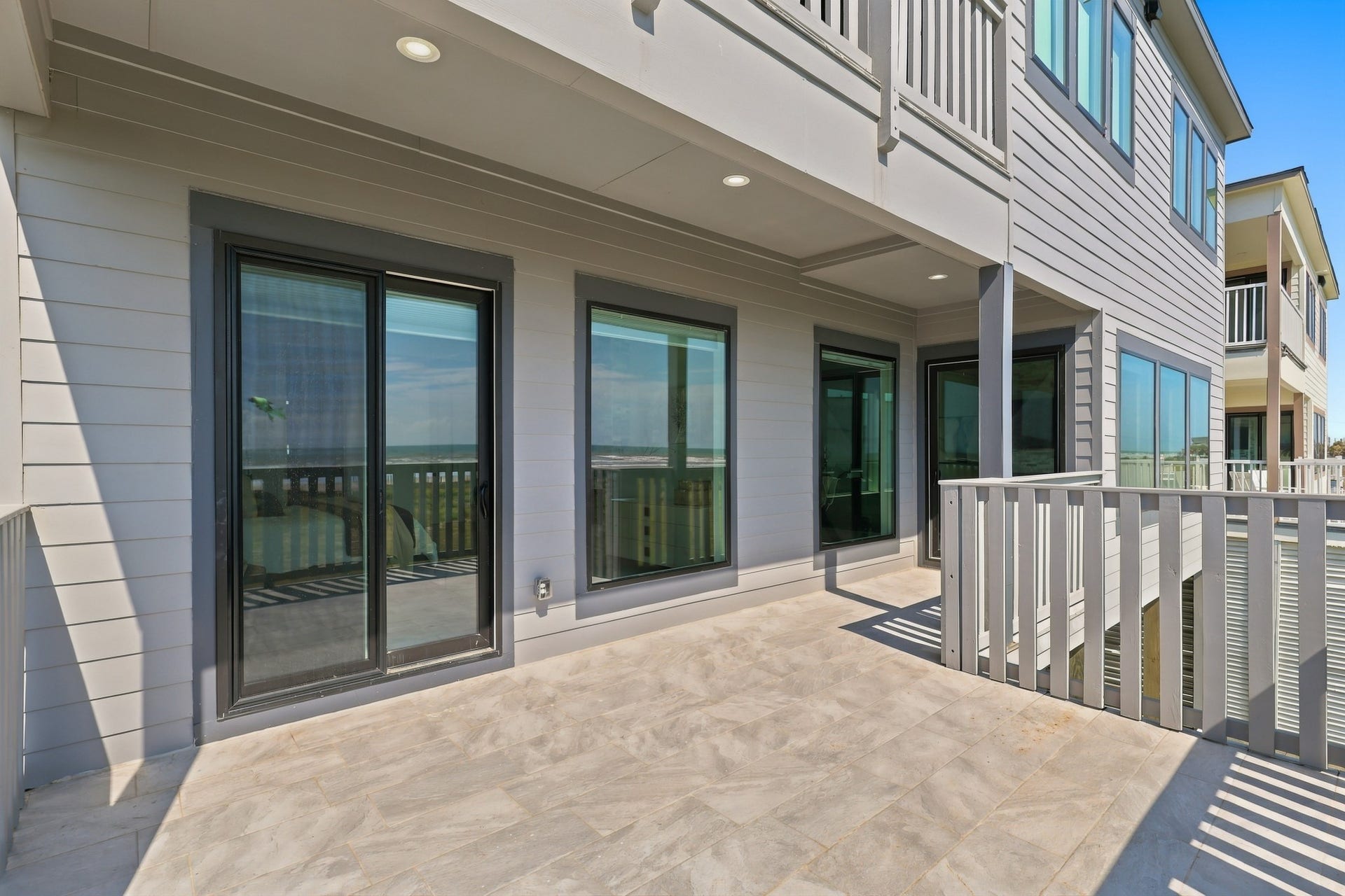 17211 Termini San Luis Pass Rd, Galveston, TX 77554 Covered deck
A spacious covered deck extends the living space outdoors, with recessed lighting and large glass doors connecting to the interior. An inviting setting for lounge seating and coastal entertaining.