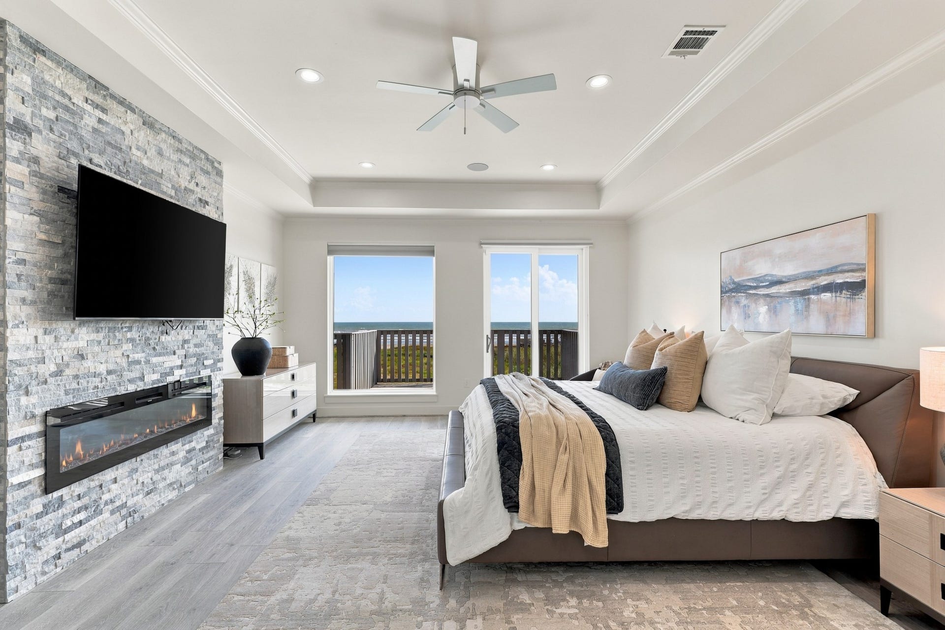 17211 Termini San Luis Pass Rd, Galveston, TX 77554 Primary bedroom, alternate view
This alternate perspective highlights the primary bedrooms spacious proportions and elegant coastal finishes. A linear fireplace and deck access create a comfortable setting for quiet evenings by the water.