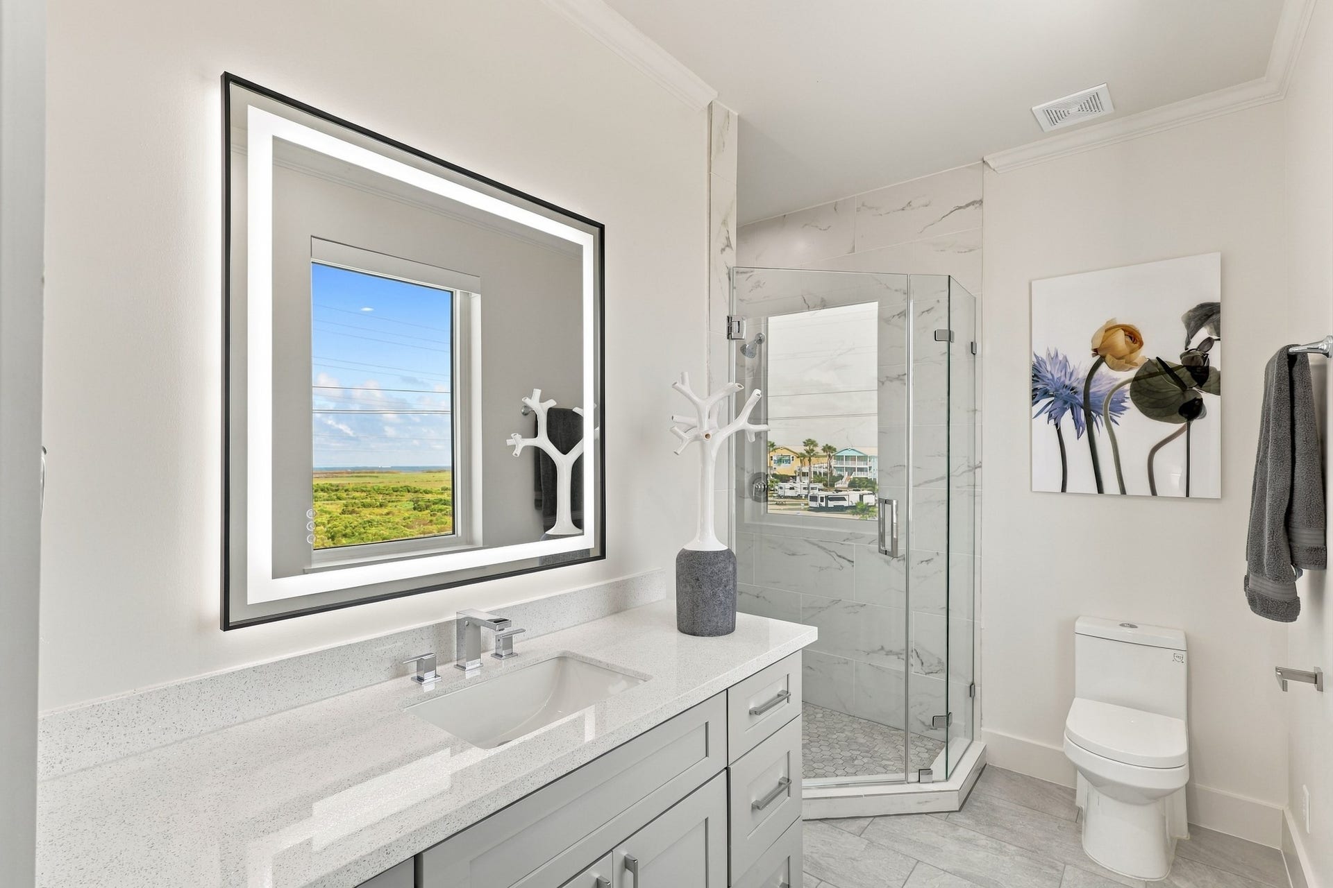 17211 Termini San Luis Pass Rd, Galveston, TX 77554 Full bathroom
Refined bathroom featuring a glass-enclosed walk-in shower, marble-look tile, and a generous gray vanity. An illuminated mirror and natural light enhance the bright, contemporary finish.