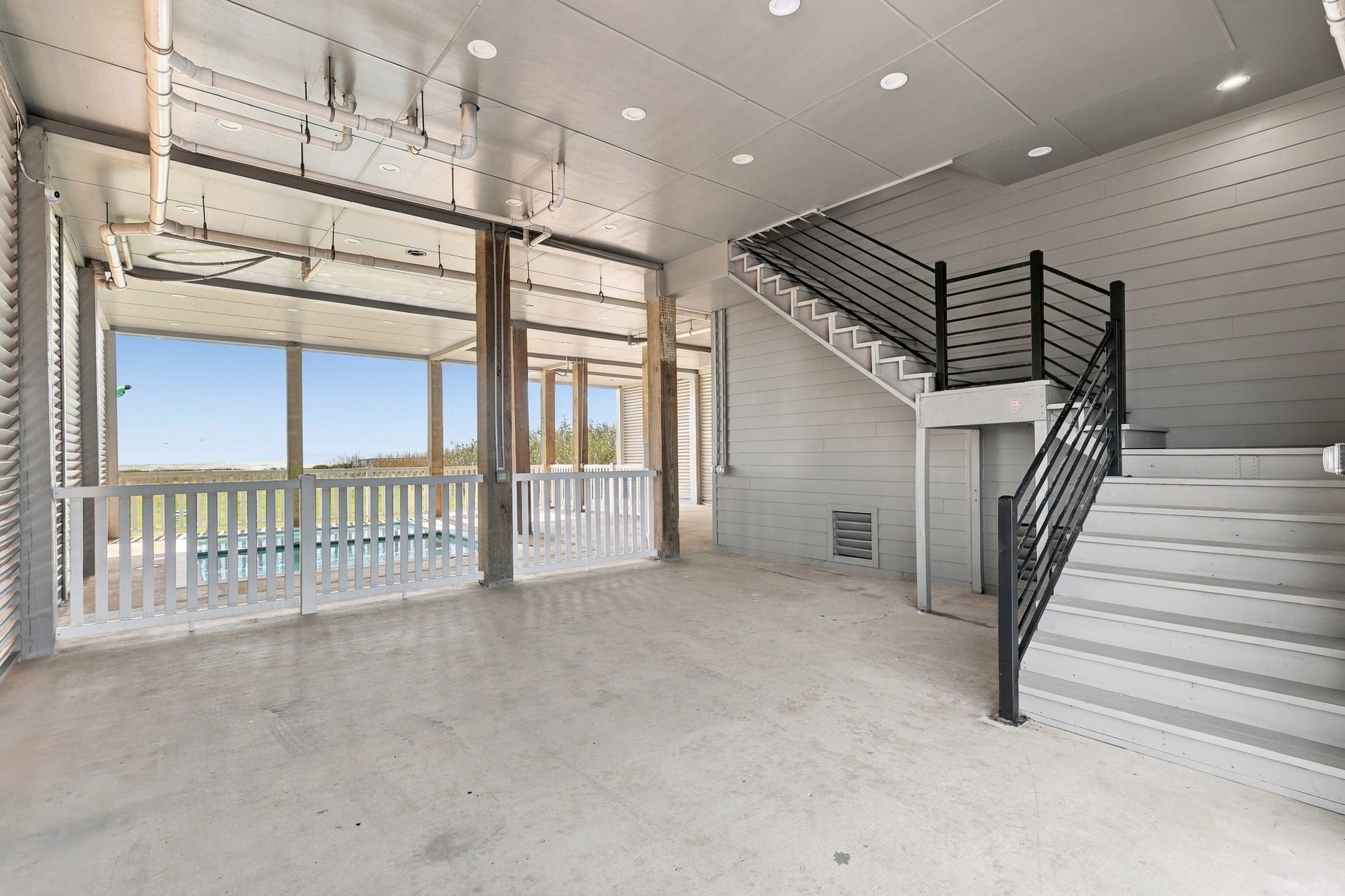 17211 Termini San Luis Pass Rd, Galveston, TX 77554 Covered ground-level space
Expansive covered ground-level space offers room for outdoor seating and gathering beside the pool area. Recessed lighting and an interior staircase connect this sheltered setting to the home above.