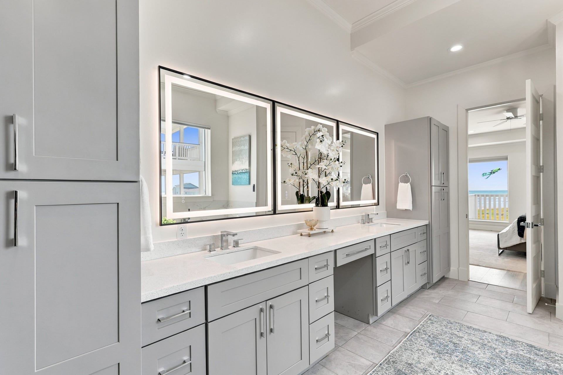 17211 Termini San Luis Pass Rd, Galveston, TX 77554 Primary vanity
The extended dual-sink vanity offers abundant drawer storage, tall cabinets, and a dedicated seated preparation area. Three illuminated mirrors brighten the space and complement its contemporary finishes.