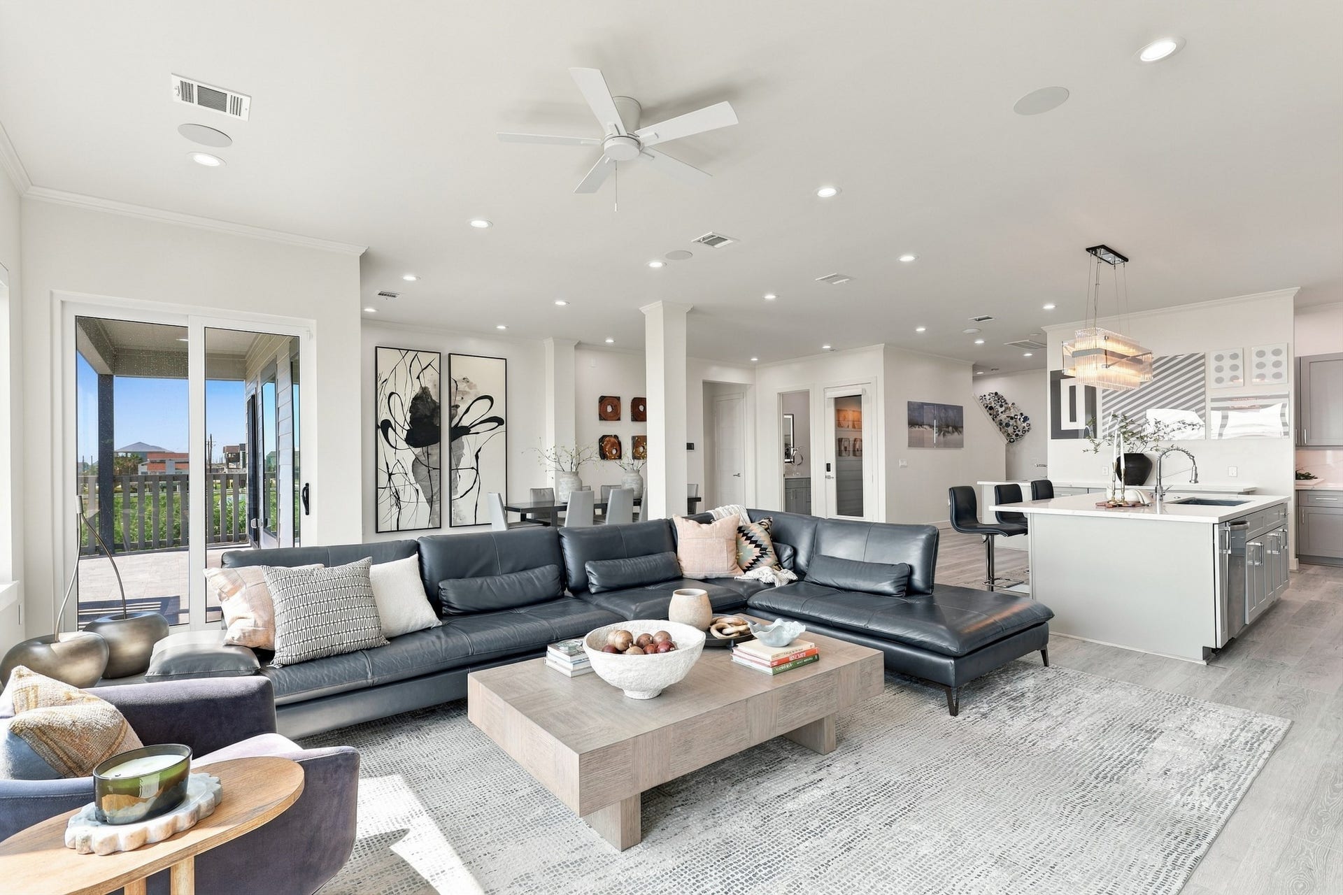 17211 Termini San Luis Pass Rd, Galveston, TX 77554 An inviting gathering space connects seamlessly to the island kitchen and dining area. Sliding glass doors open to the covered deck for easy indoor-outdoor entertaining.