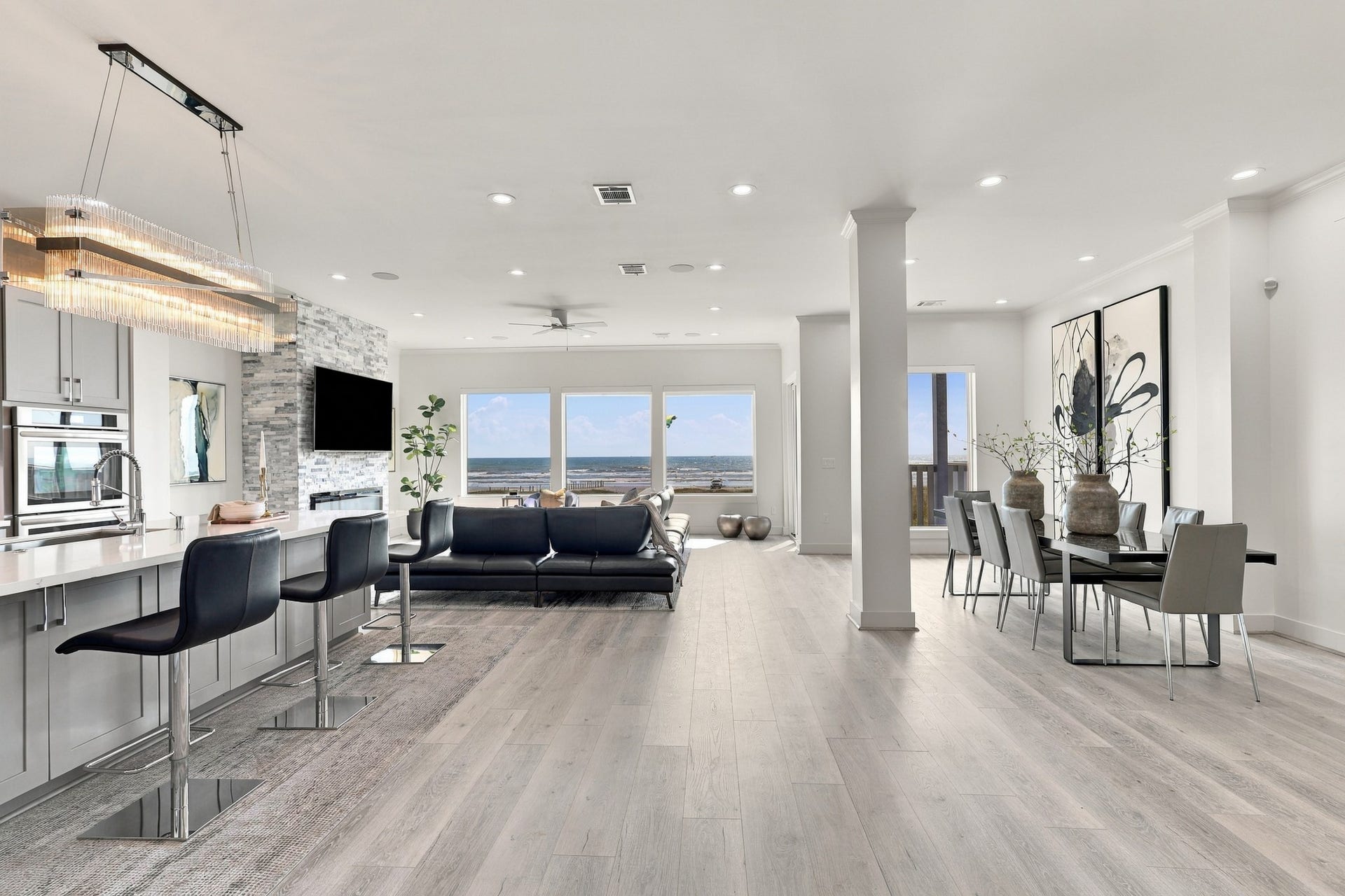 17211 Termini San Luis Pass Rd, Galveston, TX 77554 Expansive Gulf views anchor this open living space, where the kitchen, dining area, and living room flow together beautifully. A light coastal palette complements the waterfront setting.