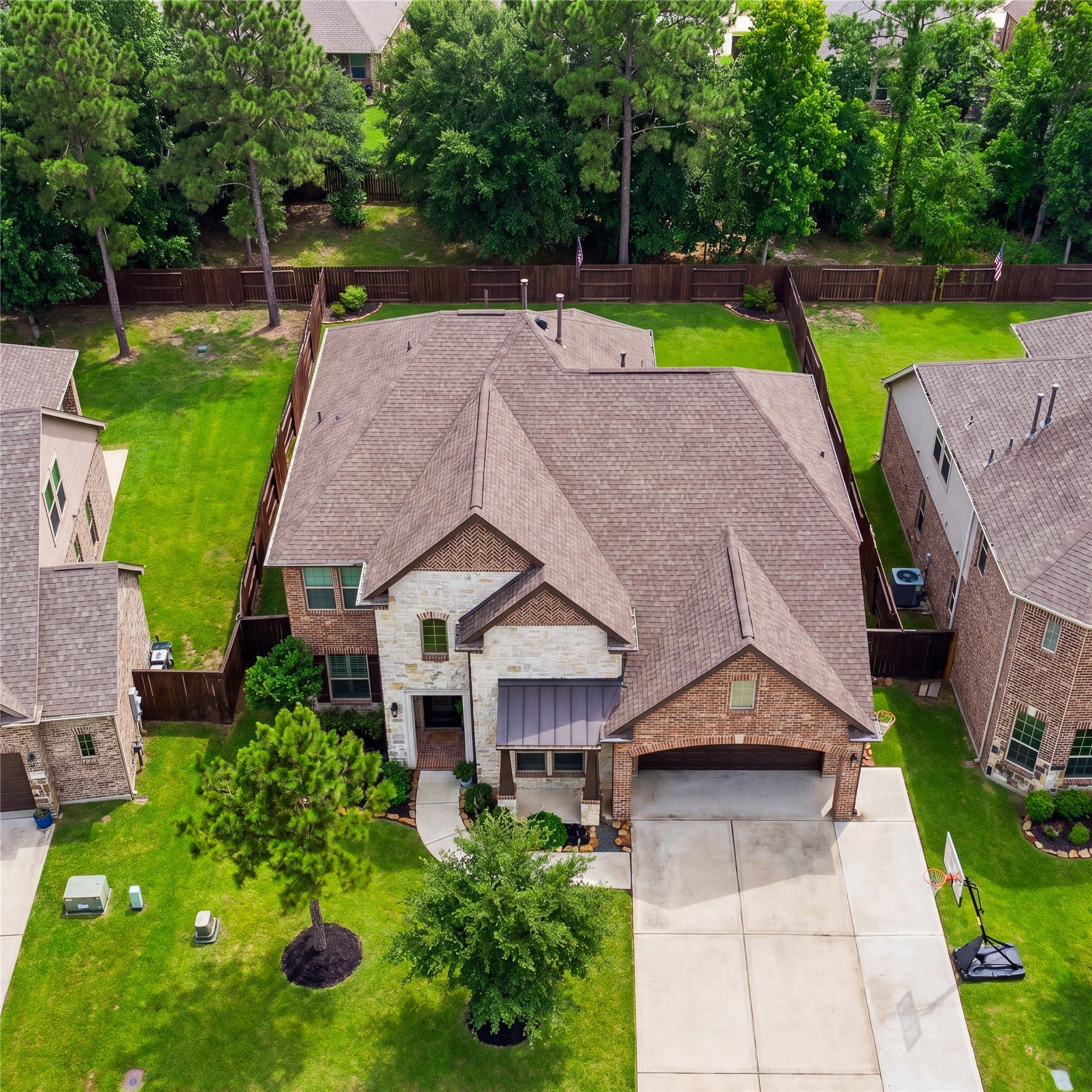 7907 Augusta Creek Court, Spring, TX 77389 This is a charming two-story home with a brick and stone exterior, featuring a spacious extended driveway and a two-car garage. The well-maintained front yard has lush greenery and mature trees, providing excellent curb appeal. The property is nestled in a serene neighborhood with a backdrop of tall trees, offering a sense of privacy and tranquility.