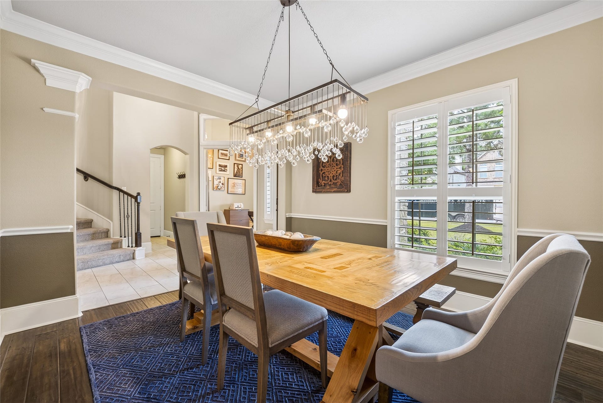 7907 Augusta Creek Court, Spring, TX 77389 This dining room features a warm, inviting atmosphere and a modern chandelier. Natural light floods through plantation shutters, enhancing the neutral color palette.