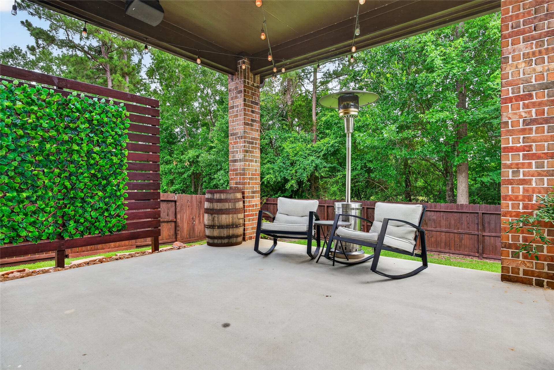7907 Augusta Creek Court, Spring, TX 77389 This inviting outdoor covered patio features a cozy seating area perfect for relaxation. The space is surrounded by greenery, lush trees, and nature.... surely offering a tranquil and private atmosphere.
