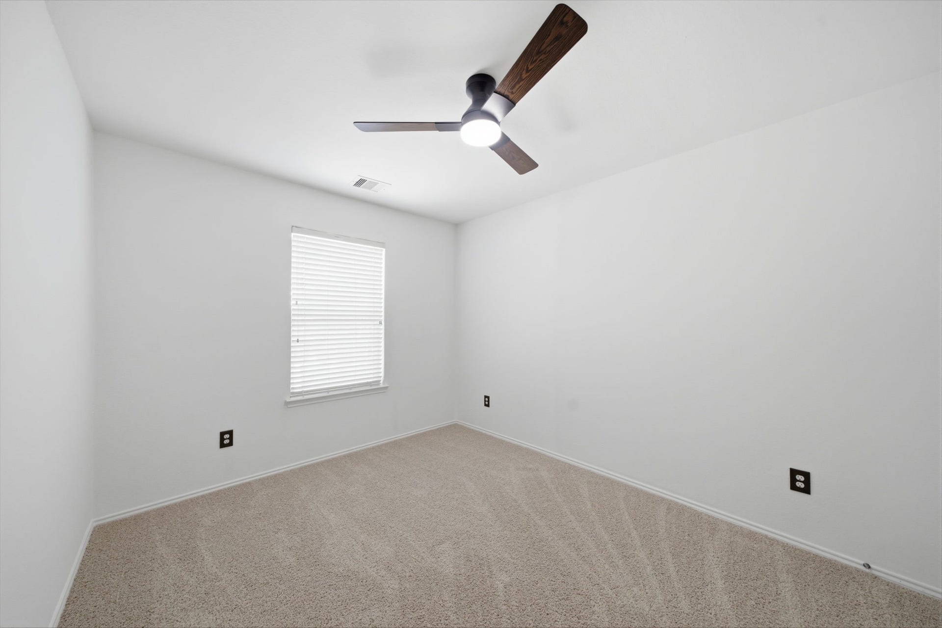 15435 Kaston Drive, Cypress, TX 77433 Plush carpet flooring and a dark-blade ceiling fan complement the fresh neutral paint in this secondary bedroom. A single window brings in natural light, framing a clean, adaptable space for rest or study.