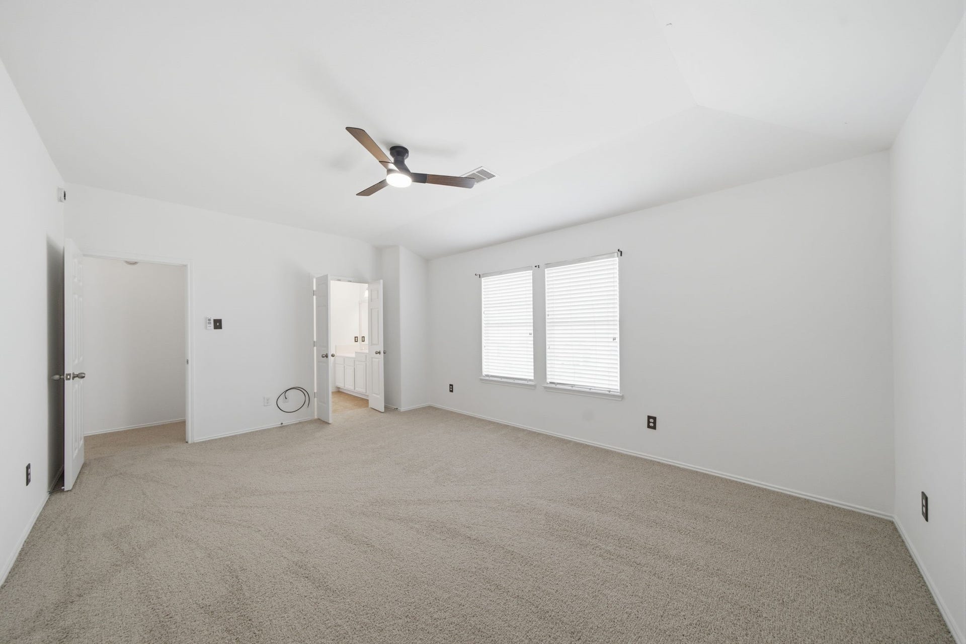 15435 Kaston Drive, Cypress, TX 77433 Soft neutral carpet and a vaulted ceiling with a modern fan define this light-filled secondary bedroom. Crisp white walls and dual windows create an open, airy atmosphere with plenty of space for personalized furnishings.