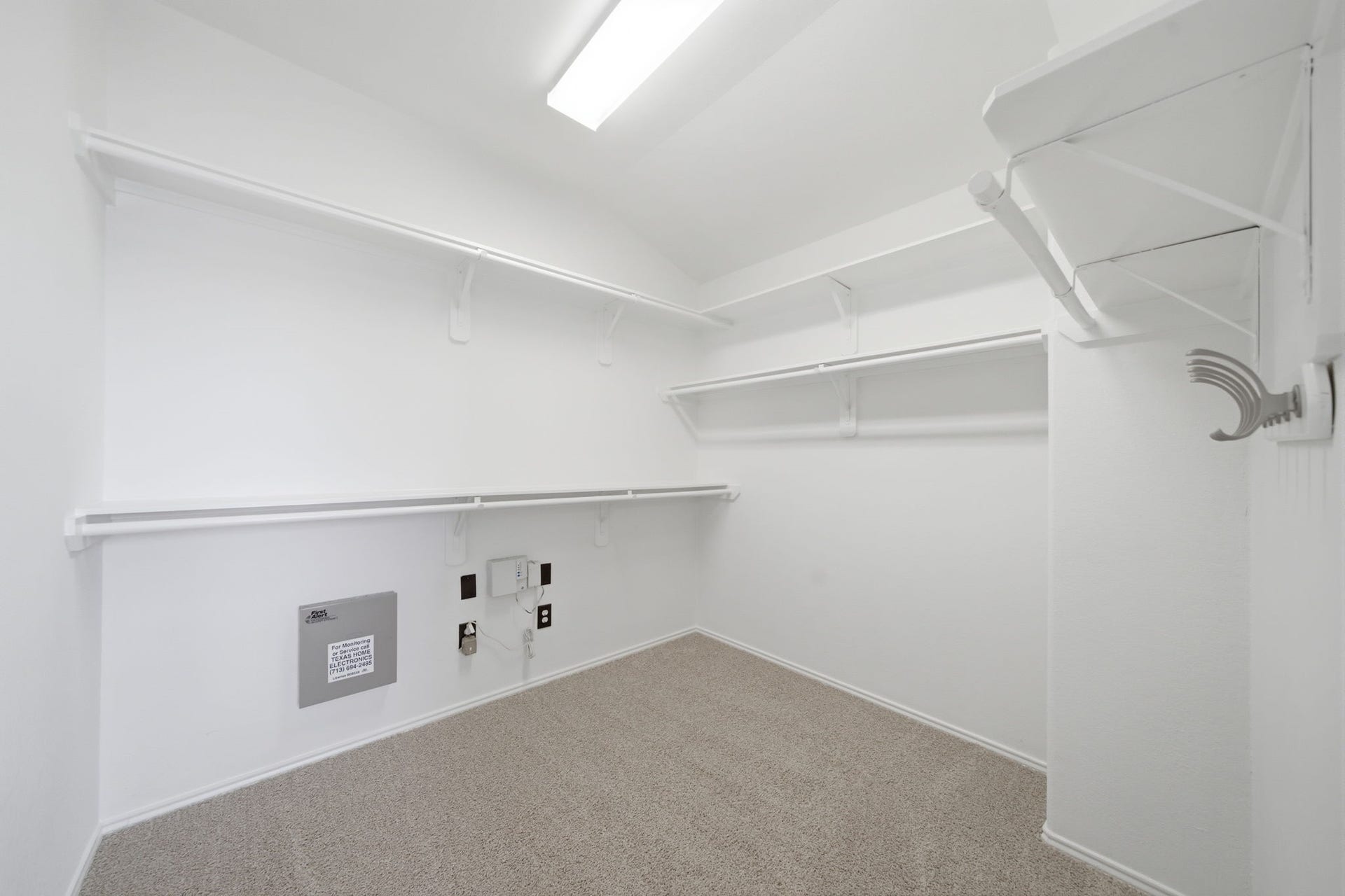 15435 Kaston Drive, Cypress, TX 77433 Extensive multi-level shelving and hanging rods maximize every inch of this primary suite's expansive walk-in closet. Soft carpet flooring and bright white finishes complete the functional storage space.