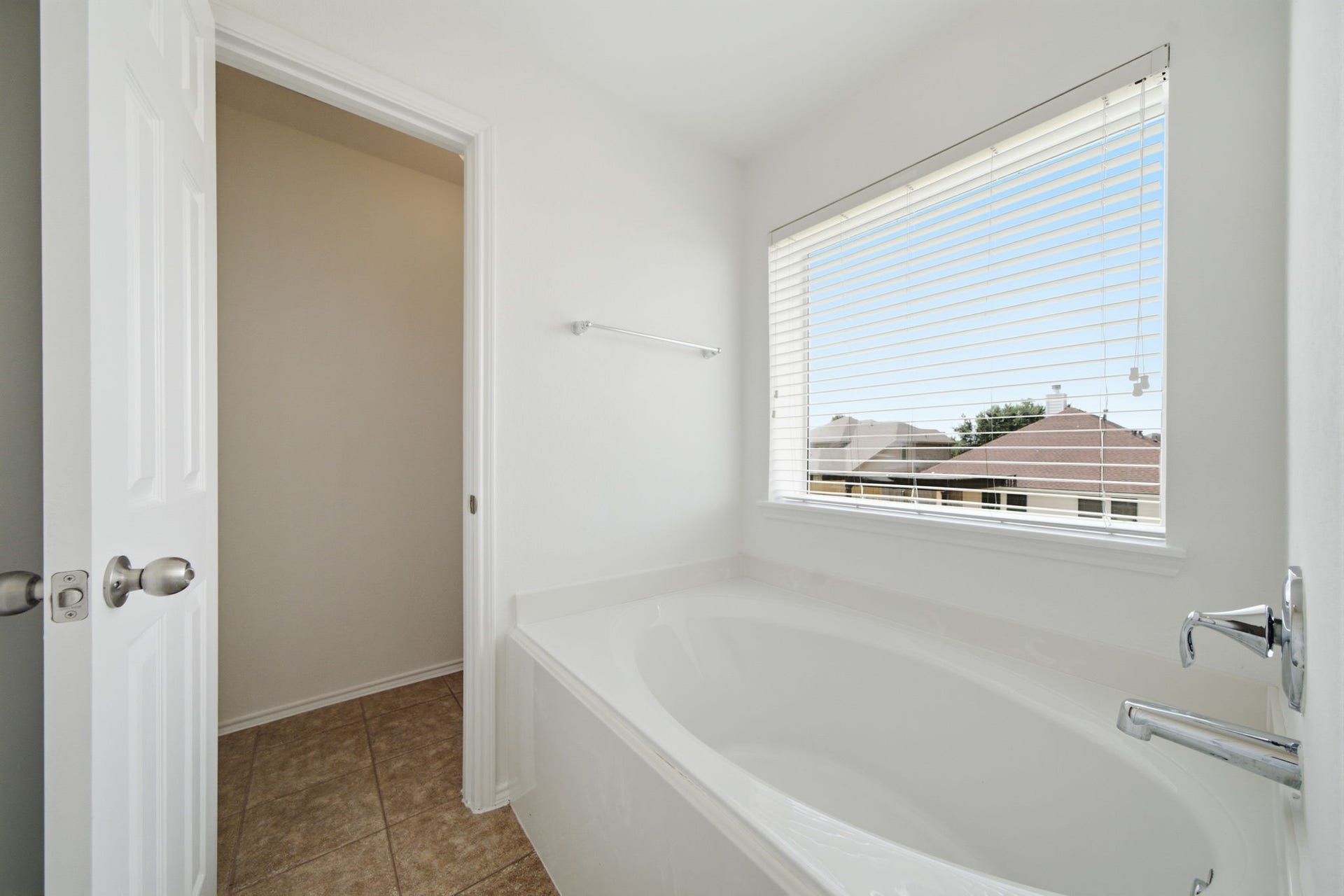 15435 Kaston Drive, Cypress, TX 77433 A deep oval soaking tub sits beneath a wide window, serving as the focal point of this primary bath. Tile flooring and a crisp white finish create a light-filled setting designed for relaxation.