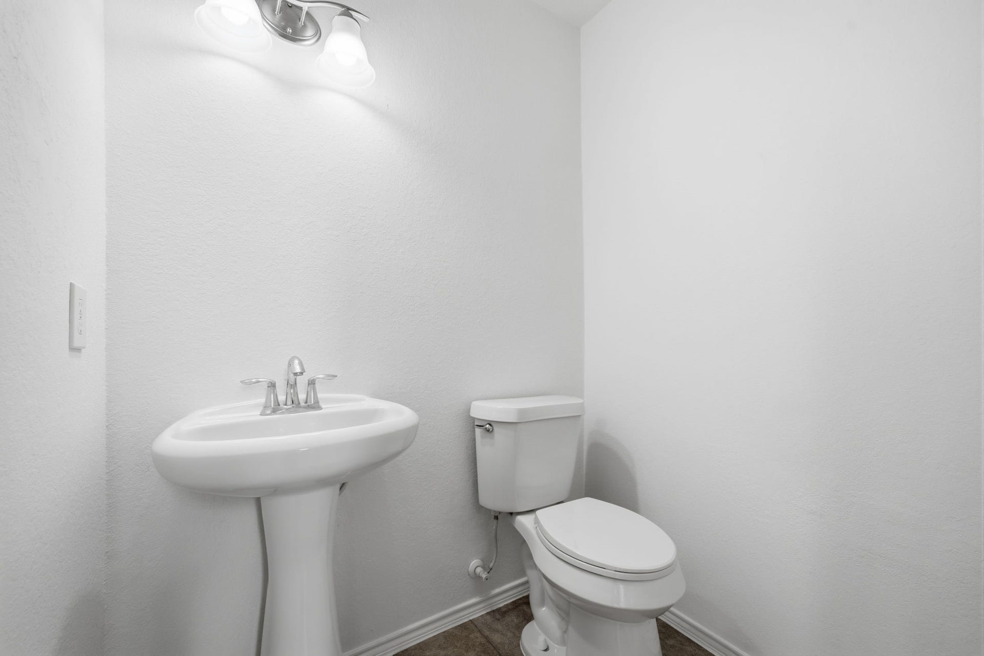 15435 Kaston Drive, Cypress, TX 77433 Tucked away for convenience, this half bath features a pedestal sink with sleek chrome fixtures and durable tile flooring.