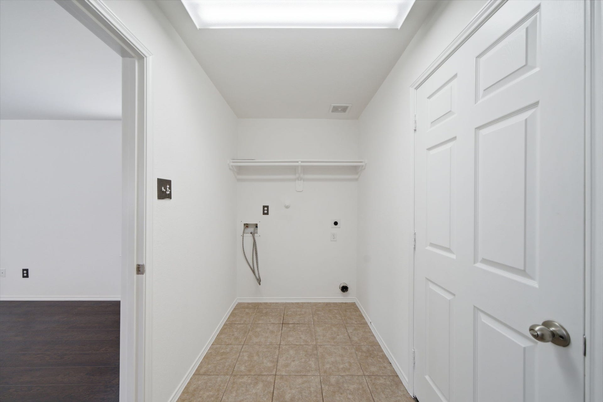 15435 Kaston Drive, Cypress, TX 77433 Durable tile flooring and overhead wire shelving define this dedicated utility room, offering convenient washer and dryer hookups.