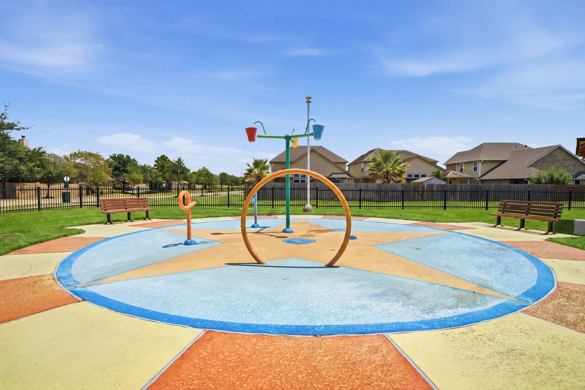 15435 Kaston Drive, Cypress, TX 77433 Bright star-patterned concrete paving anchors this neighborhood splash pad, featuring fun water features and surrounding park benches.