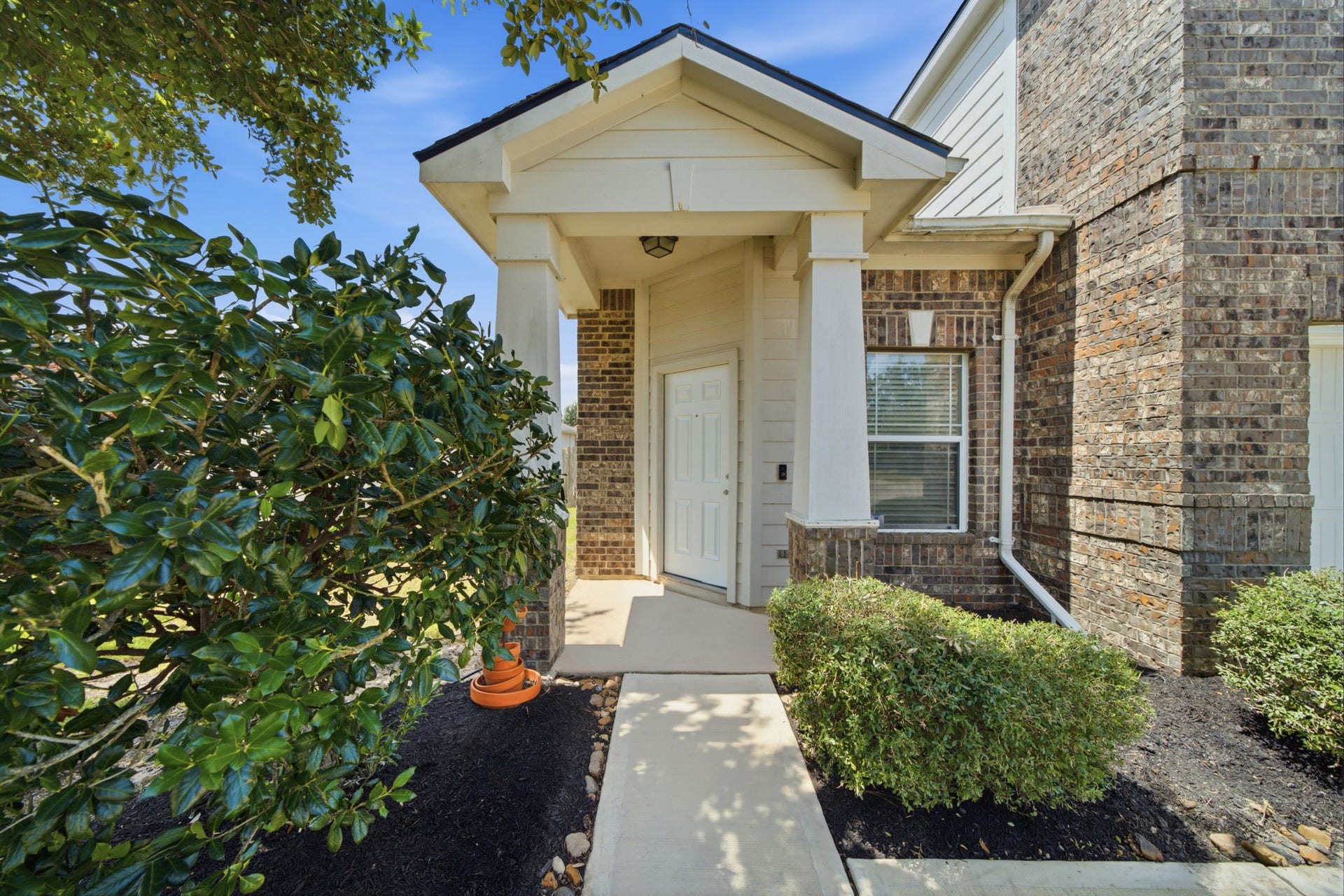 15435 Kaston Drive, Cypress, TX 77433 A covered entryway with handsome square columns and crisp trim highlights the classic brick facade, creating an inviting approach to the front door.