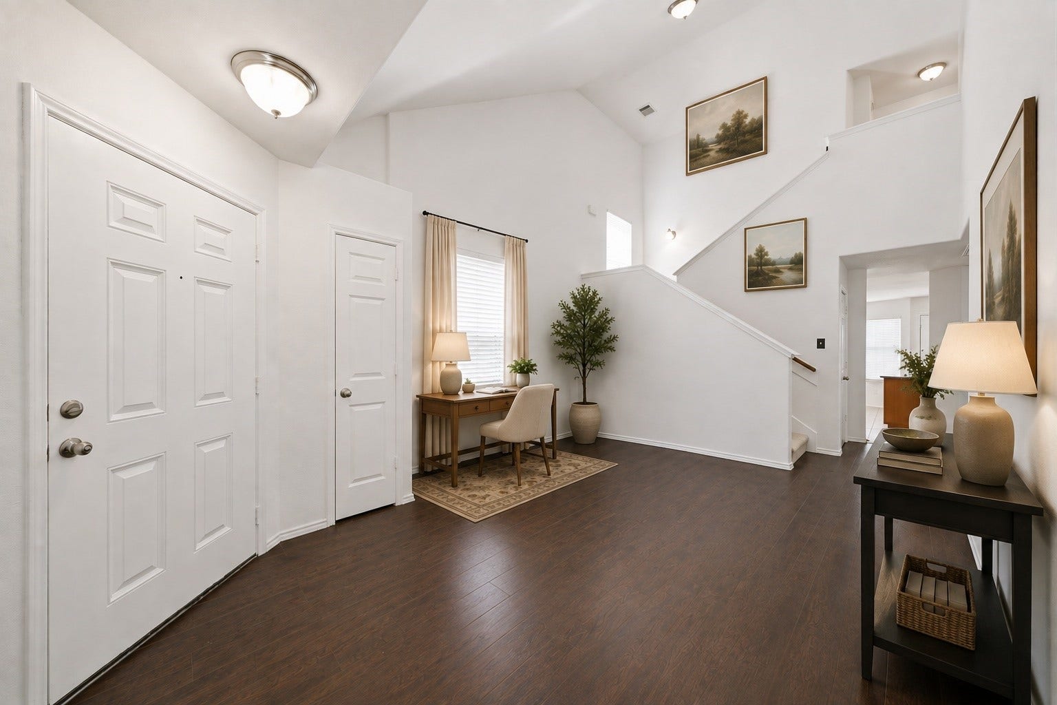 15435 Kaston Drive, Cypress, TX 77433 Vaulted ceilings and rich wood-look flooring create an airy welcome in this light-filled foyer. An alcove accommodates a compact desk, while the main staircase leads to the second-floor living spaces. This photo has been virtually staged.