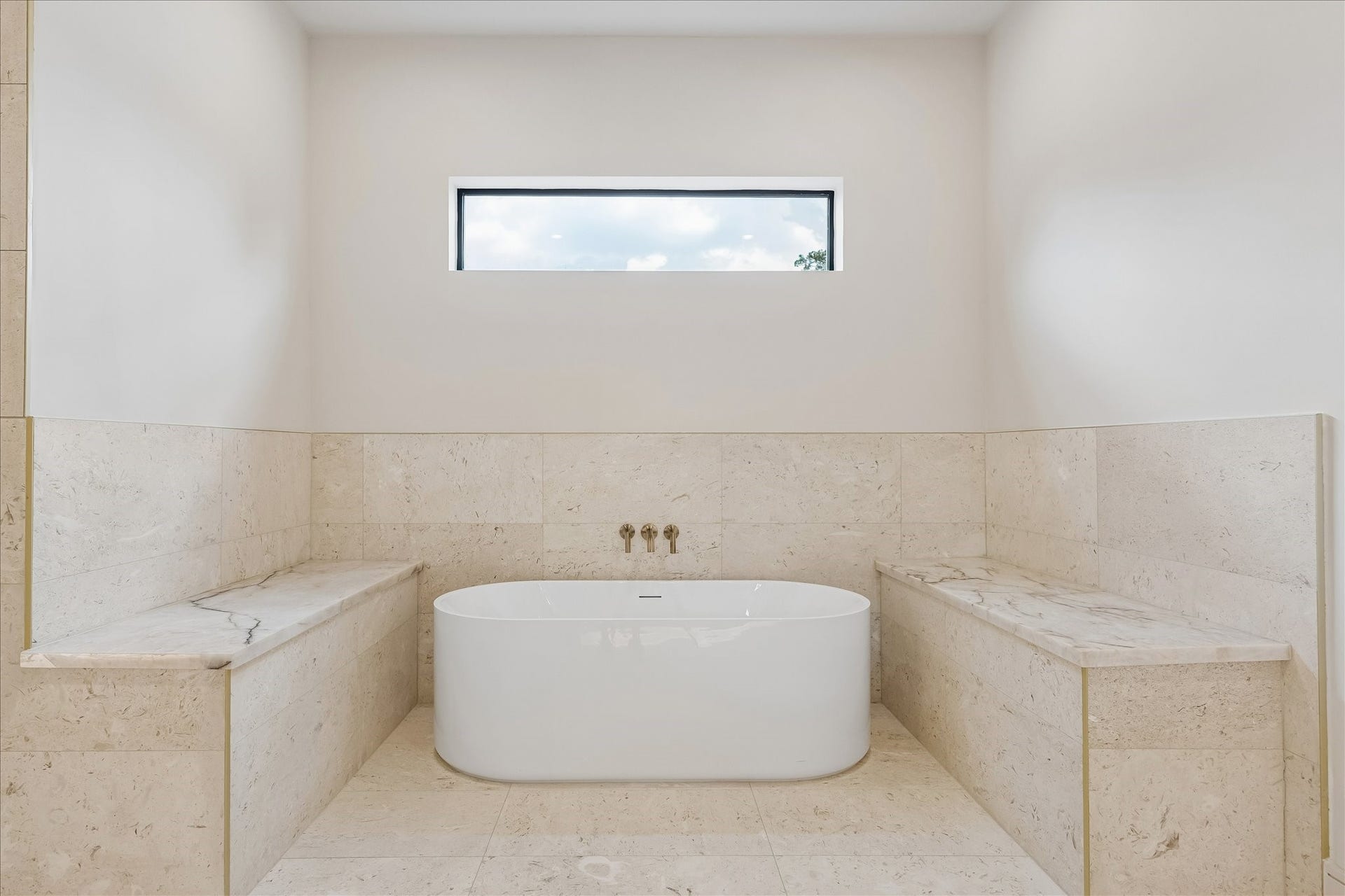 316 W 30th Street, Houston, TX 77018 Unwind in a freestanding soaking tub framed by natural stone surrounds, creating a true spa inspired retreat. Elevated finishes, warm brass fixtures, and abundant natural light bring a sense of calm to the primary bath.