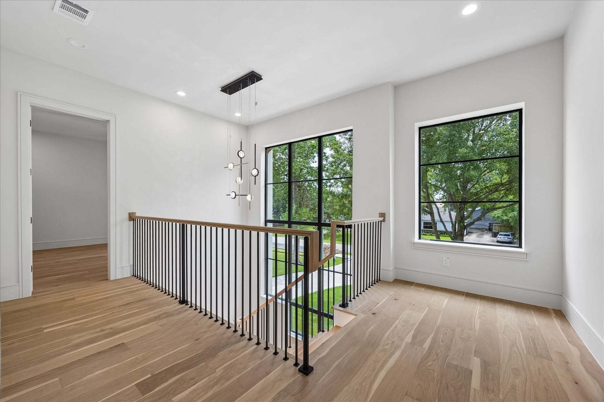 316 W 30th Street, Houston, TX 77018 A striking two story staircase is framed by a custom specialty window unit - lifted into place by crane - that fills the landing with natural light. LED lighting and custom fabricated stair nosing milled from the flooring itself pair with a white oak handrail and metal balusters and posts for a clean architectural statement. An open upper landing enhances the homes airy, connected design.