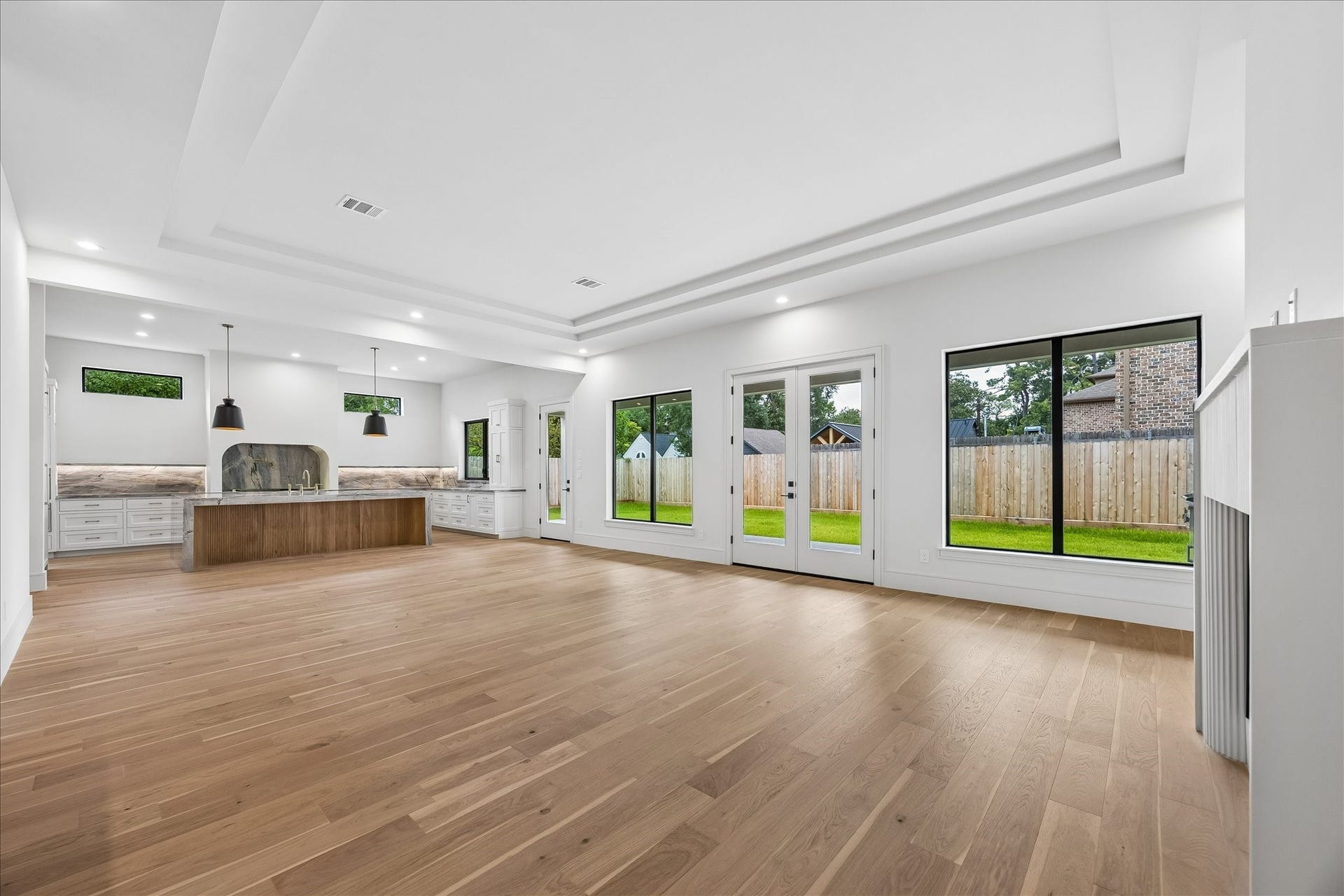 316 W 30th Street, Houston, TX 77018 Vaulted tray ceilings and walls of windows fill the open living spaces with natural light while creating a seamless connection to the covered patio and backyard. Thoughtfully designed sightlines keep the kitchen, dining, and living areas connected without sacrificing a sense of scale.