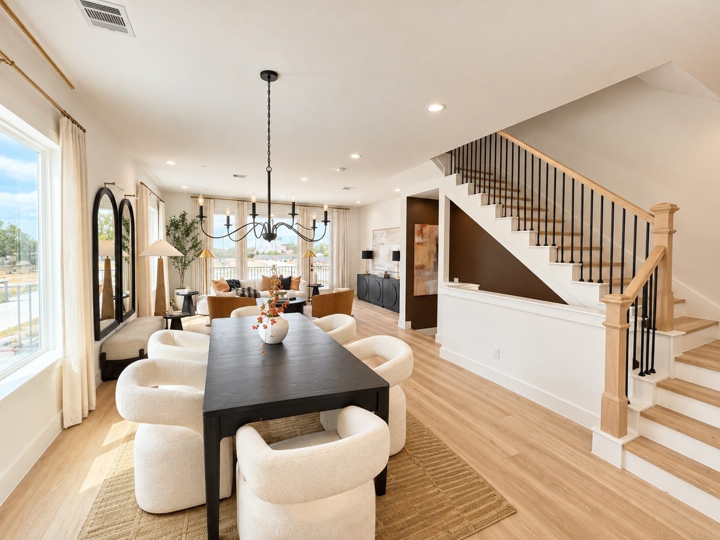 509 Hillwood Heights Drive, Houston, TX 77091 Spacious open-concept living area with elegant wood flooring, a modern black dining table, cozy seating, and a stylish staircase, perfect for entertaining.