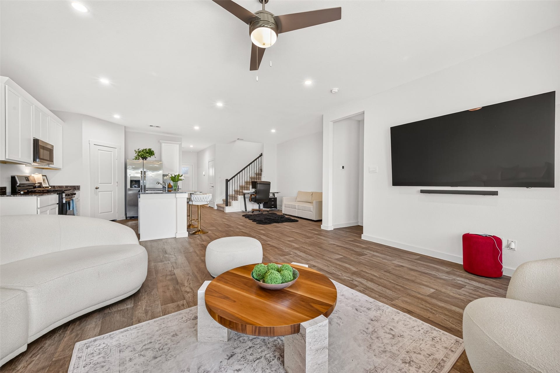 Spacious open-concept living area features modern finishes, a sleek kitchen with stainless steel appliances, and a cozy lounge space perfect for relaxation.