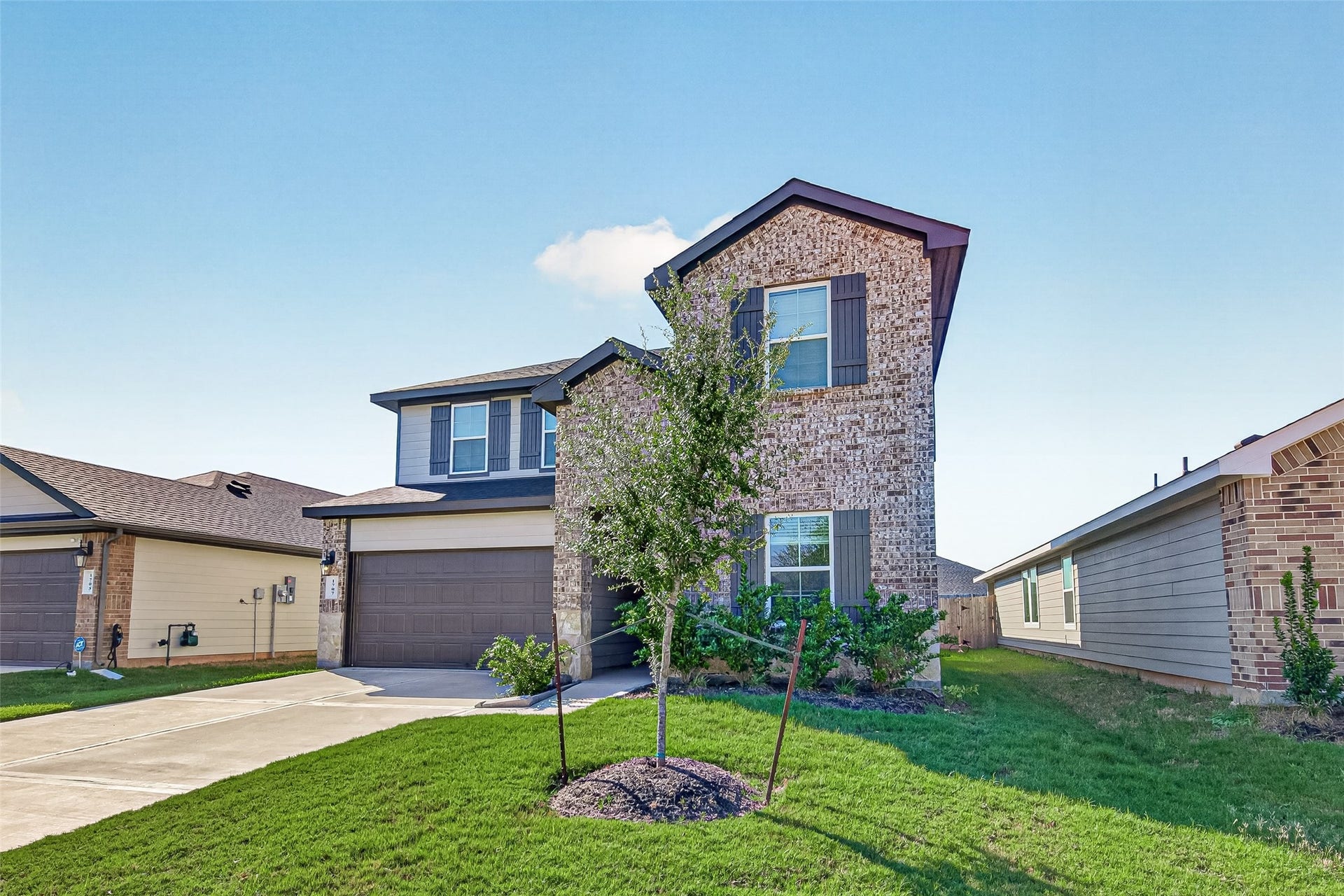 Charming two-story brick home with a well-maintained front yard, attached two-car garage, and inviting curb appeal.