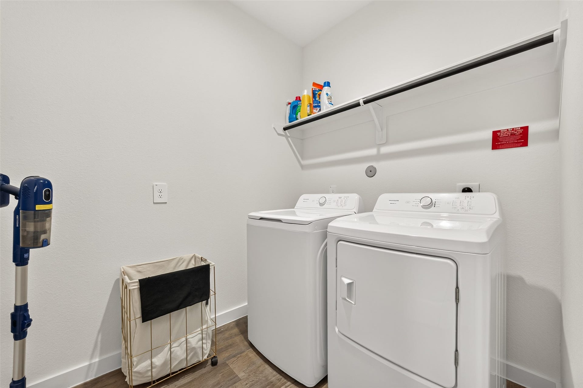 Bright and functional laundry room equipped with a washer, dryer, and convenient shelving for storage.