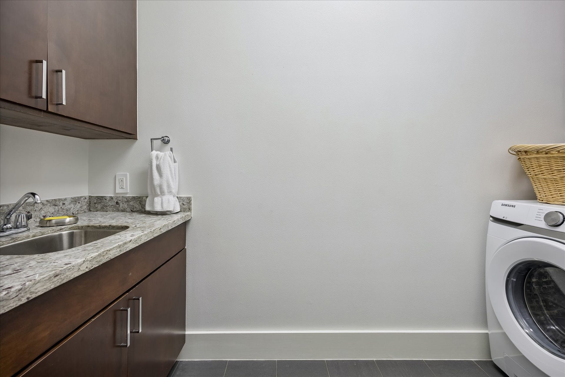 LAUNDRY ROOM with storage cabinets and sink.