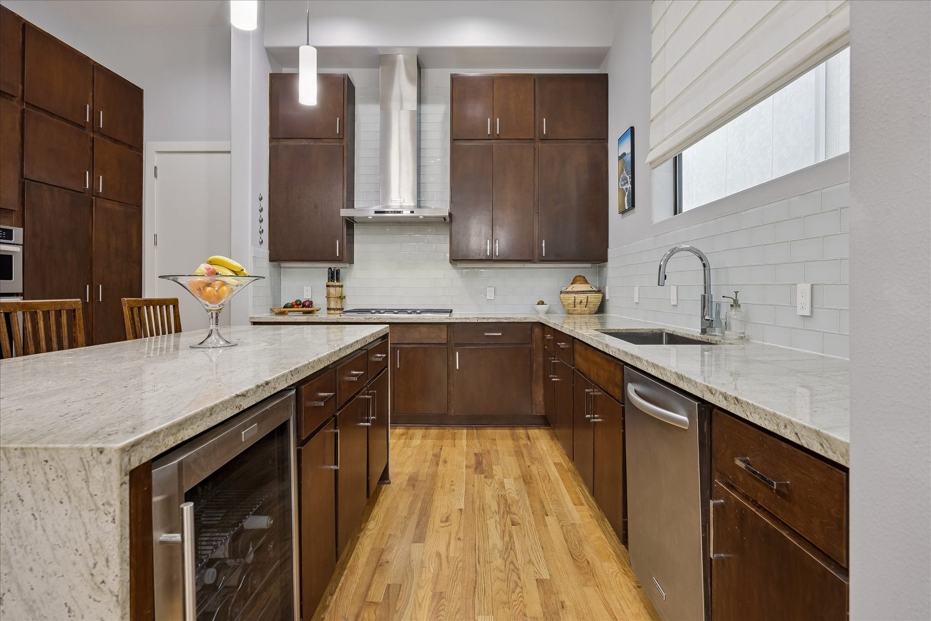 Gourmet chef's KITCHEN with waterfall countertops; an abundance of cabinets and storage space; and a wine / beverage fridge.