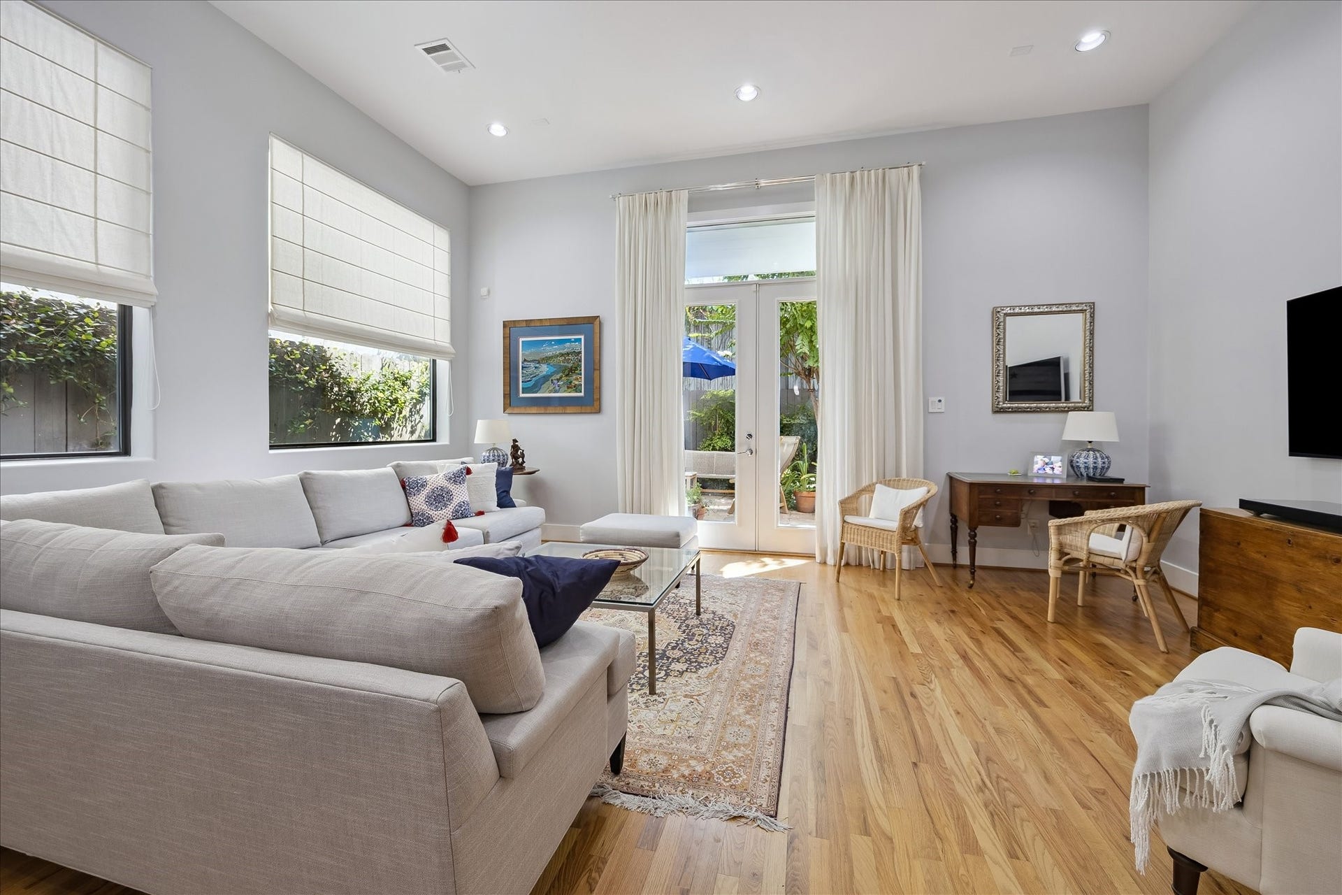 LIVING ROOM is large enough to position furniture in several different ways. The high ceilings of the first floor give the rooms an extra airy and roomy feel. The glass door leads to a private back patio.