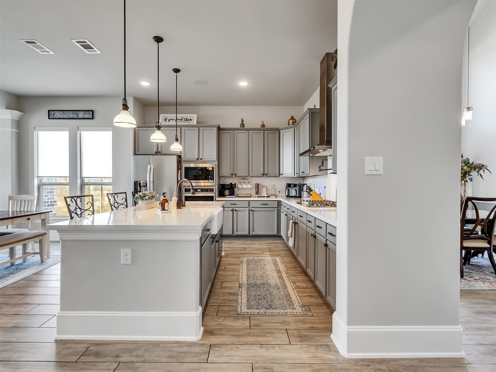 10302 Muir Peak Drive, Rosharon, TX 77583 Modern kitchen with sleek gray cabinetry and spacious island with bar seating.