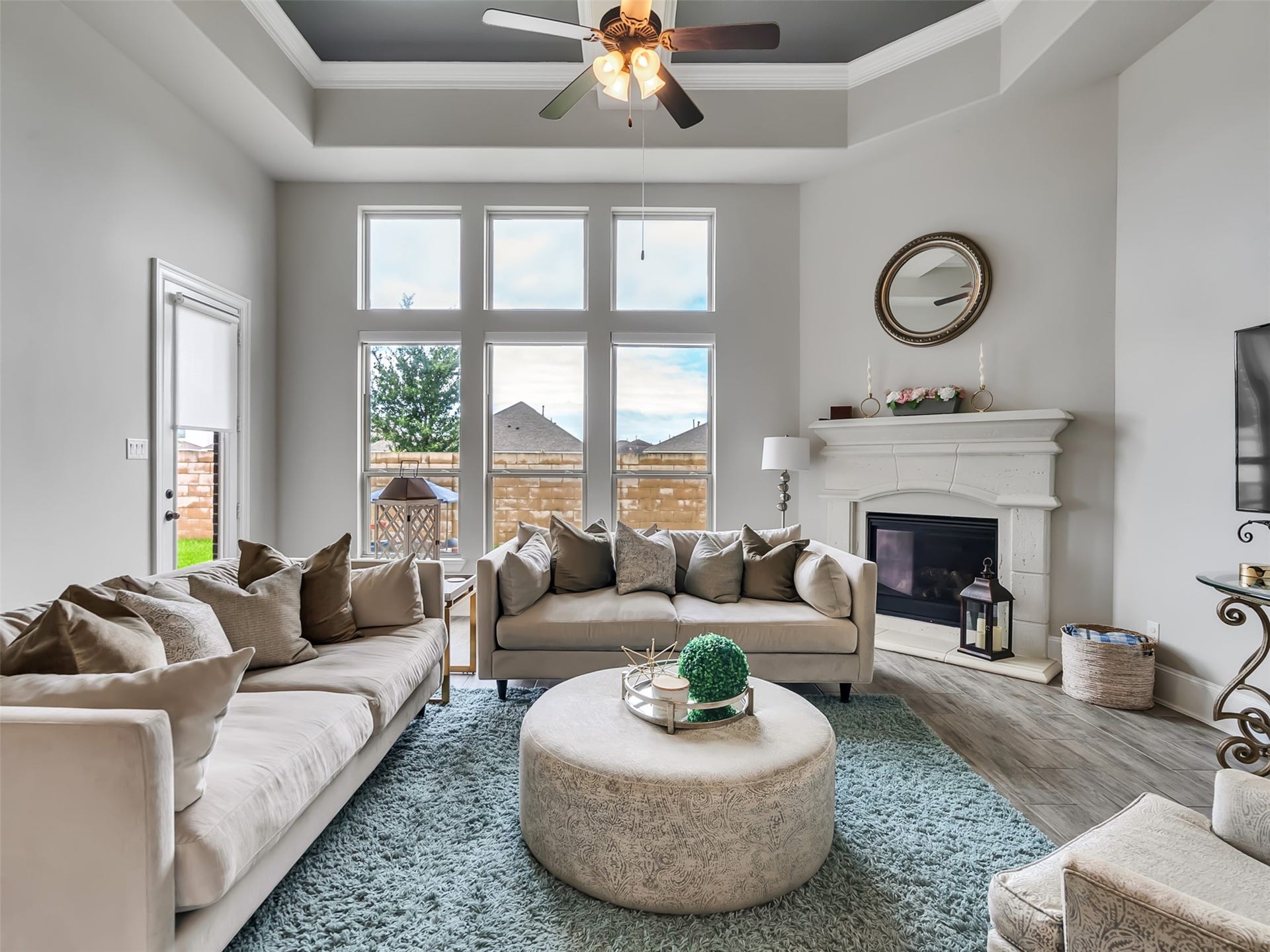 10302 Muir Peak Drive, Rosharon, TX 77583 This spacious family room features coffered ceilings, crown molding, and large windows.