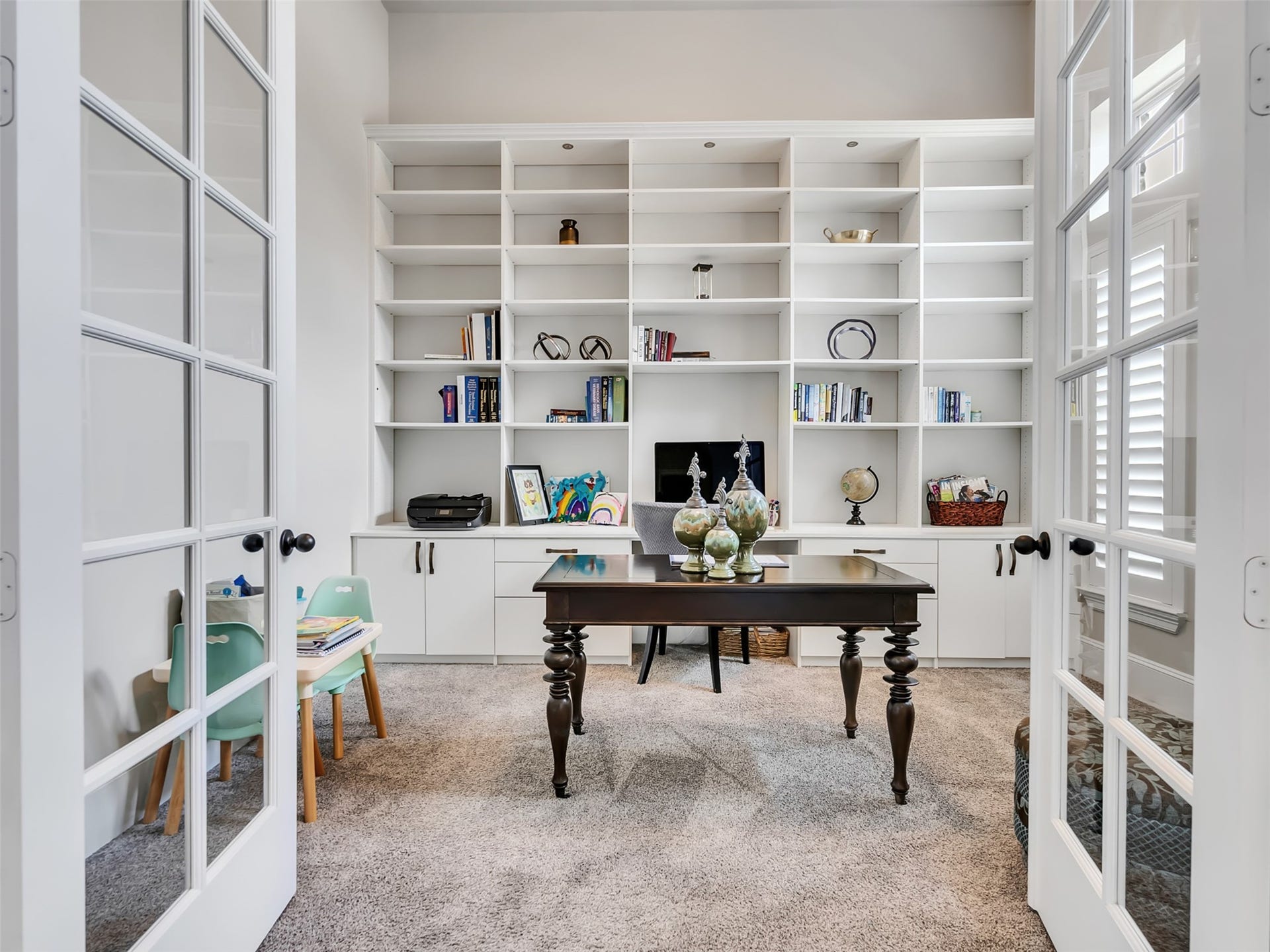 10302 Muir Peak Drive, Rosharon, TX 77583 Home office with French doors and built-in bookshelves along with natural lighting.
