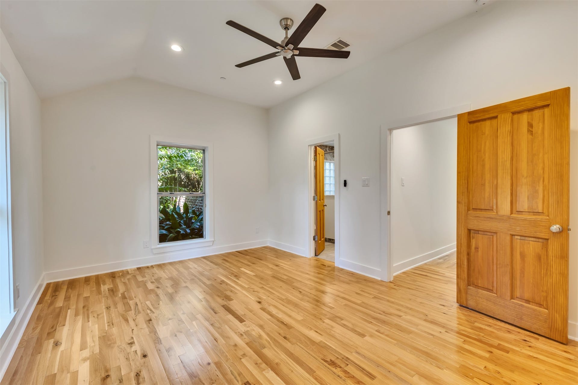 Secondary ensuite bedroom with warm wood flooring.