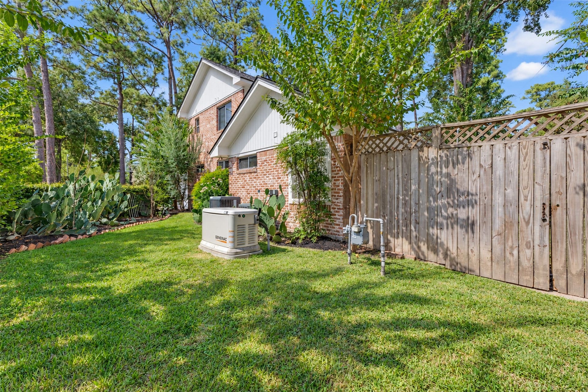 View of the side yard which includes a Generac generator.