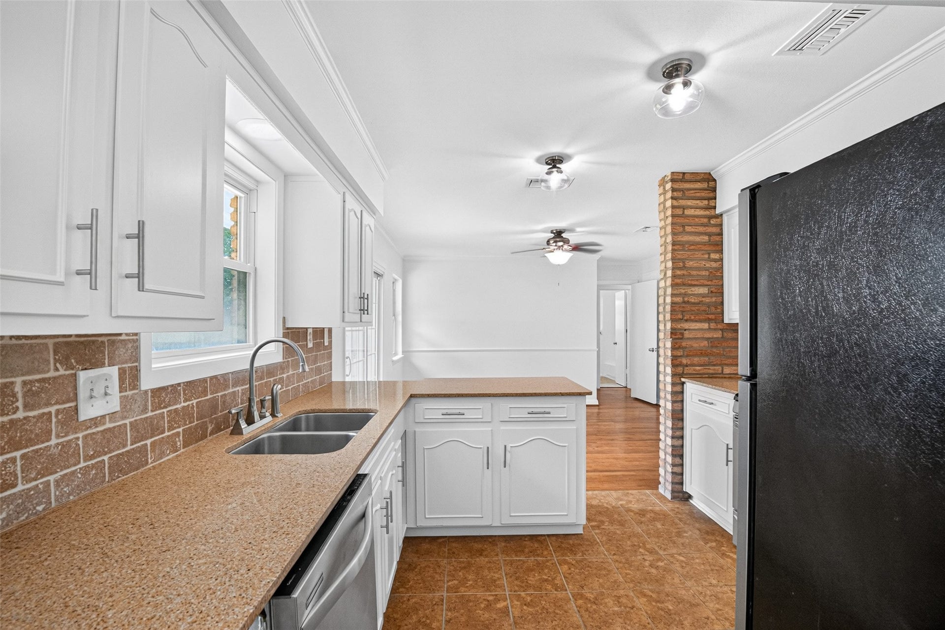 11227 Greenwillow Street, Houston, TX 77035 Stainless steel sink. Kitchen opens to dining area.