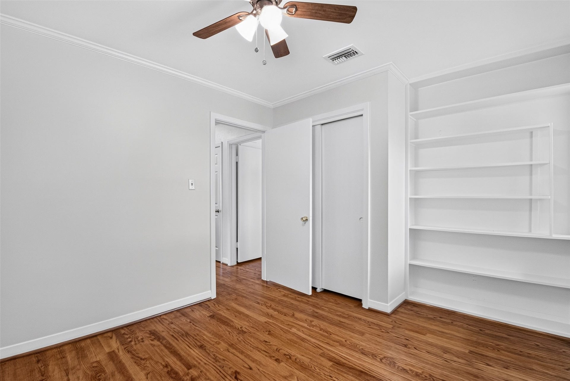 11227 Greenwillow Street, Houston, TX 77035 Another view of guest bedroom with floor-to-ceiling shelves and crown molding.