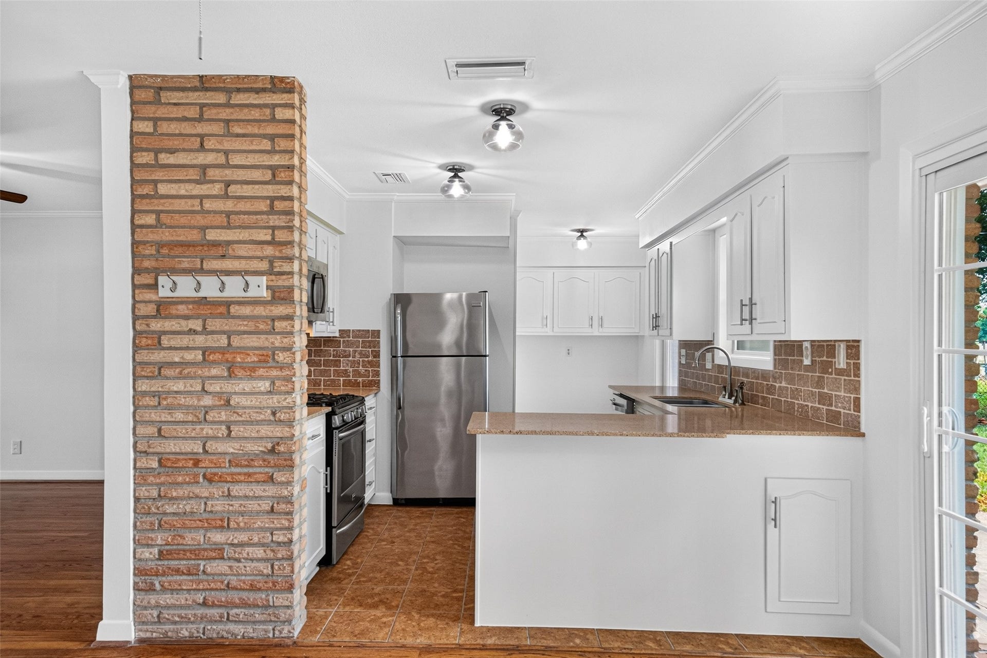 11227 Greenwillow Street, Houston, TX 77035 Updated kitchen with tile flooring, sleek countertops and brick tile backsplash.