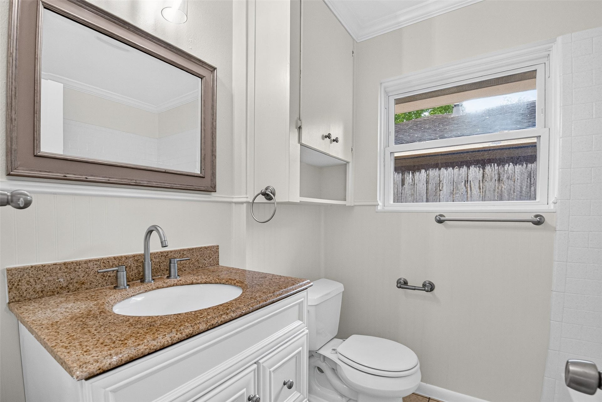 11227 Greenwillow Street, Houston, TX 77035 Updated hall bathroom with storage space in vanity and cabinet over toilet. Brushed nickel hardware.