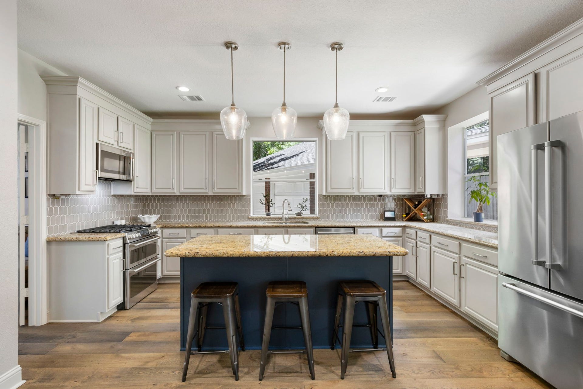 98 W Night Heron Place, The Woodlands, TX 77382 The renovated kitchen features an oversized island, abundant cabinet space, and an open layout designed for both everyday living and entertaining.