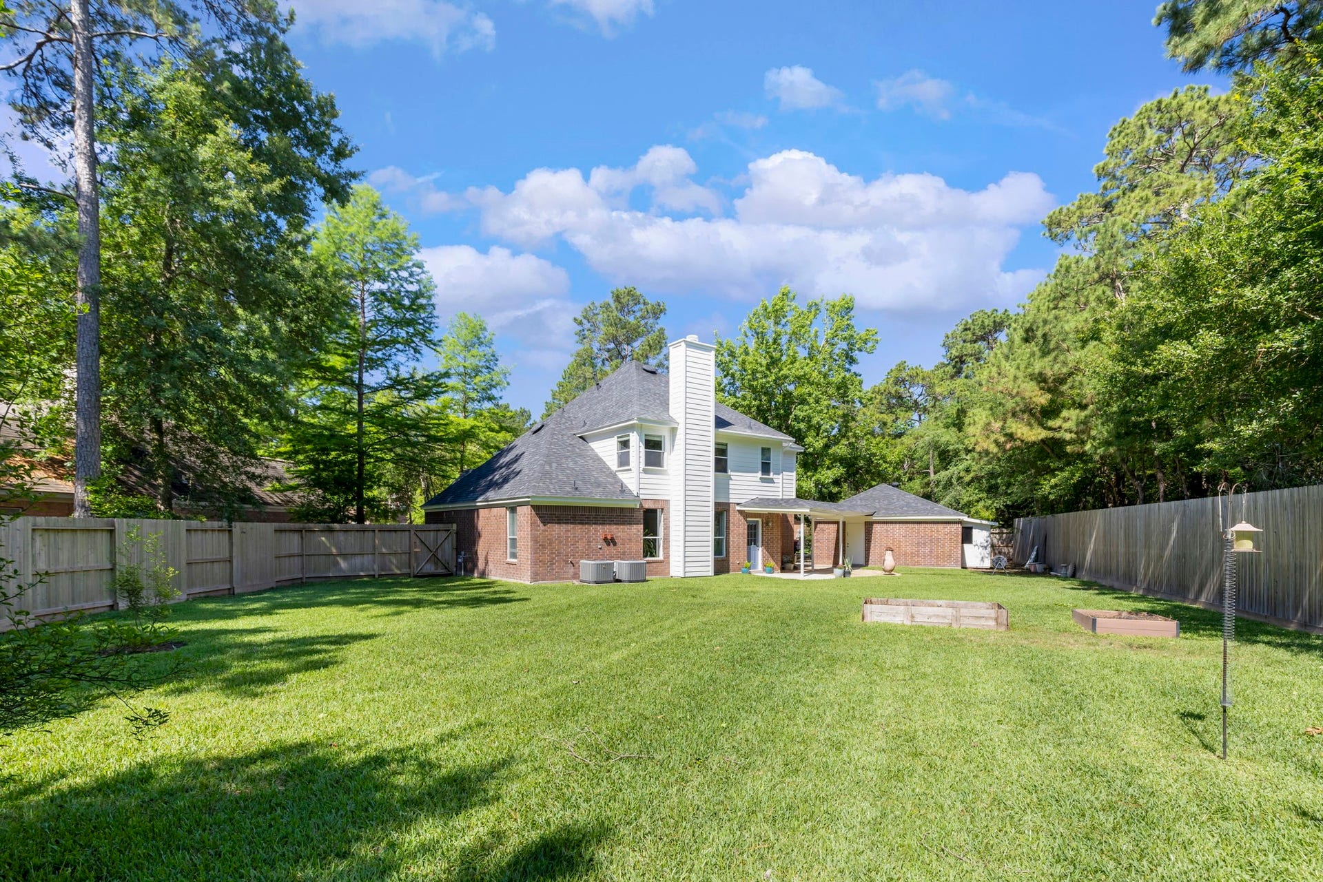 98 W Night Heron Place, The Woodlands, TX 77382 The expansive backyard offers a peaceful setting with mature trees and added privacy along the rear fence line.