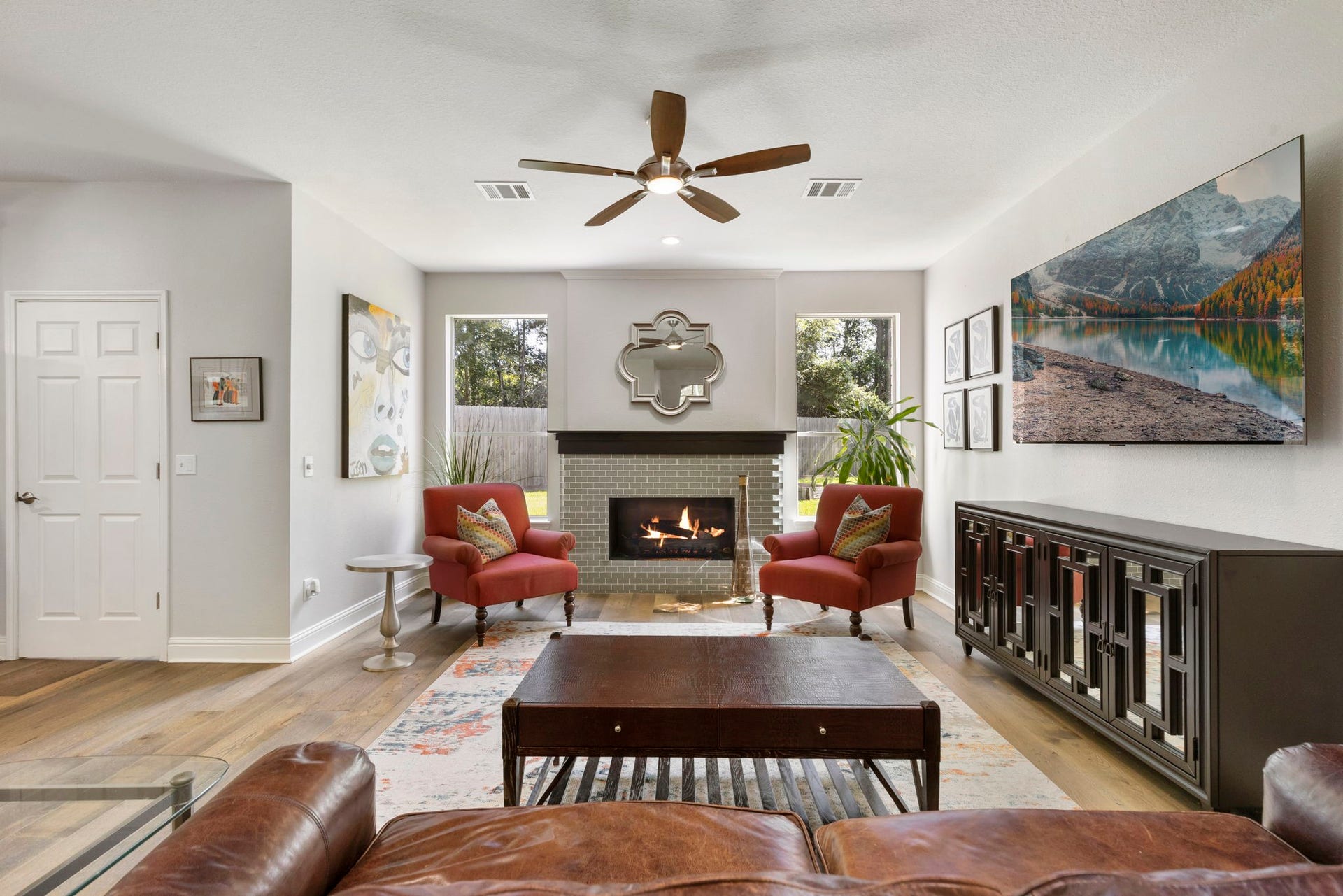 98 W Night Heron Place, The Woodlands, TX 77382 The living room features a cozy updated fireplace, large windows, and an open layout ideal for everyday living.