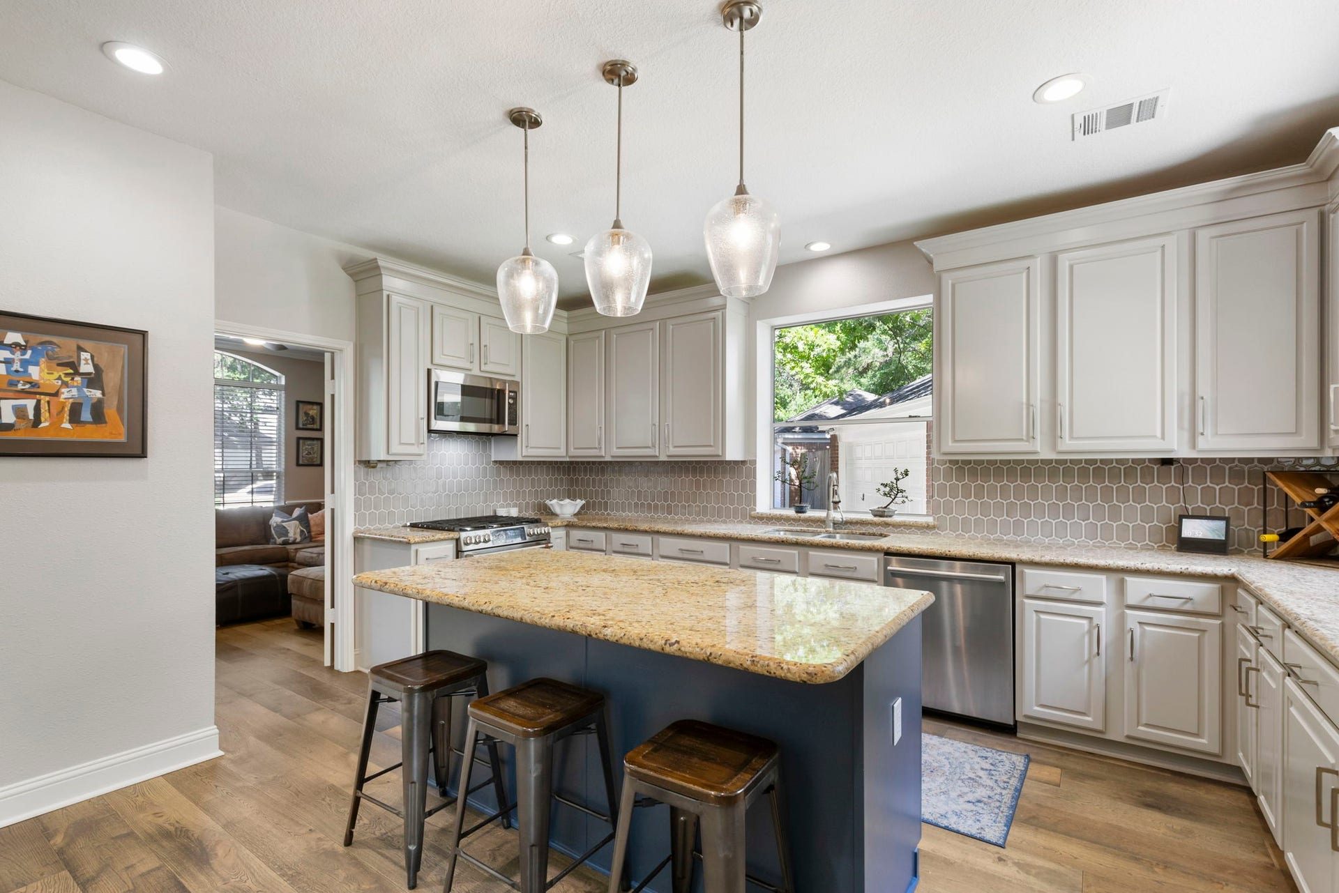 98 W Night Heron Place, The Woodlands, TX 77382 Updated lighting, stainless steel appliances, and timeless finishes give the kitchen a clean and modern feel.