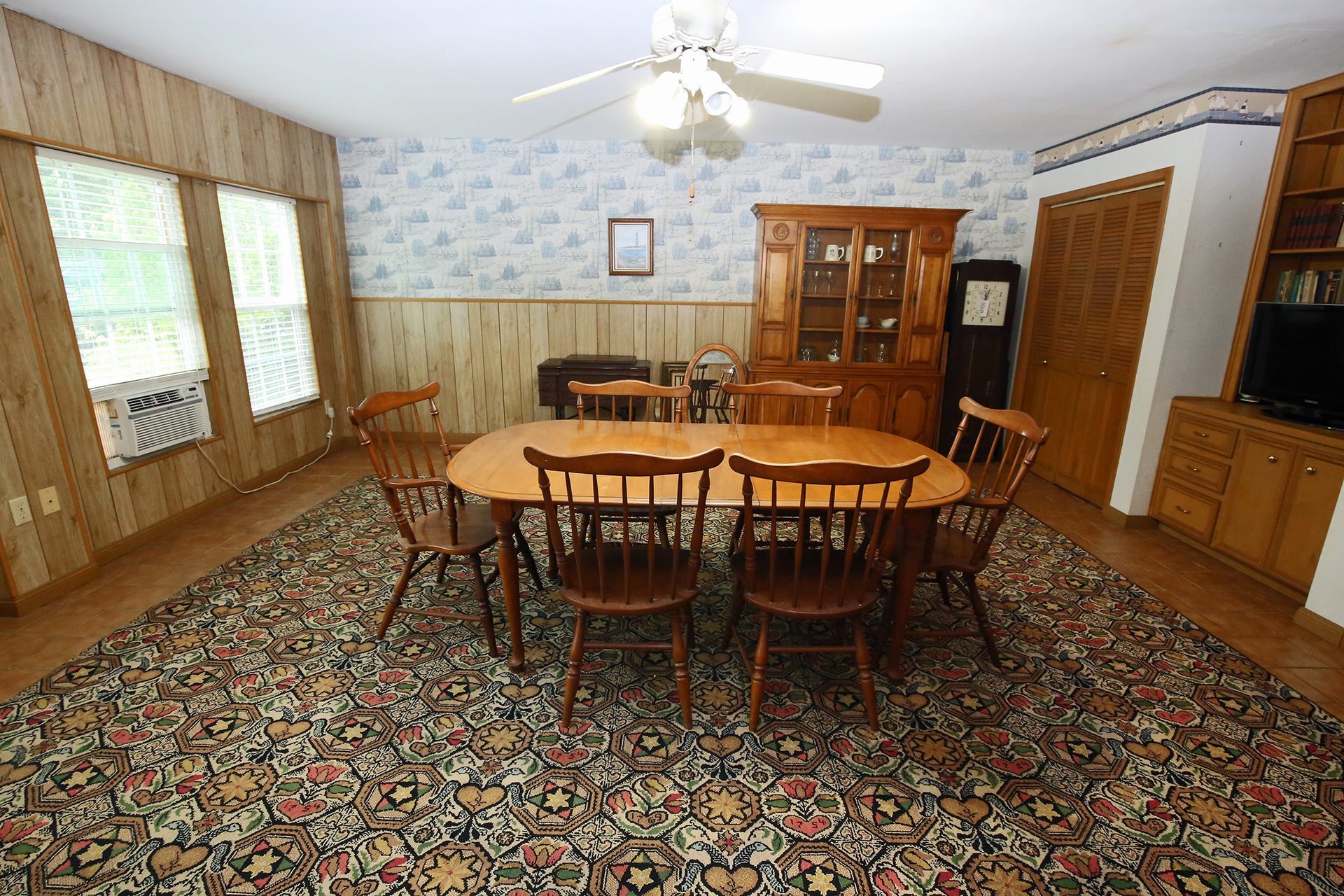 3804 Shady Lane, Santa Fe, TX 77517 Spacious dining room with natural light, cozy wood paneling, and elegant built-in storage. Perfect for gatherings.