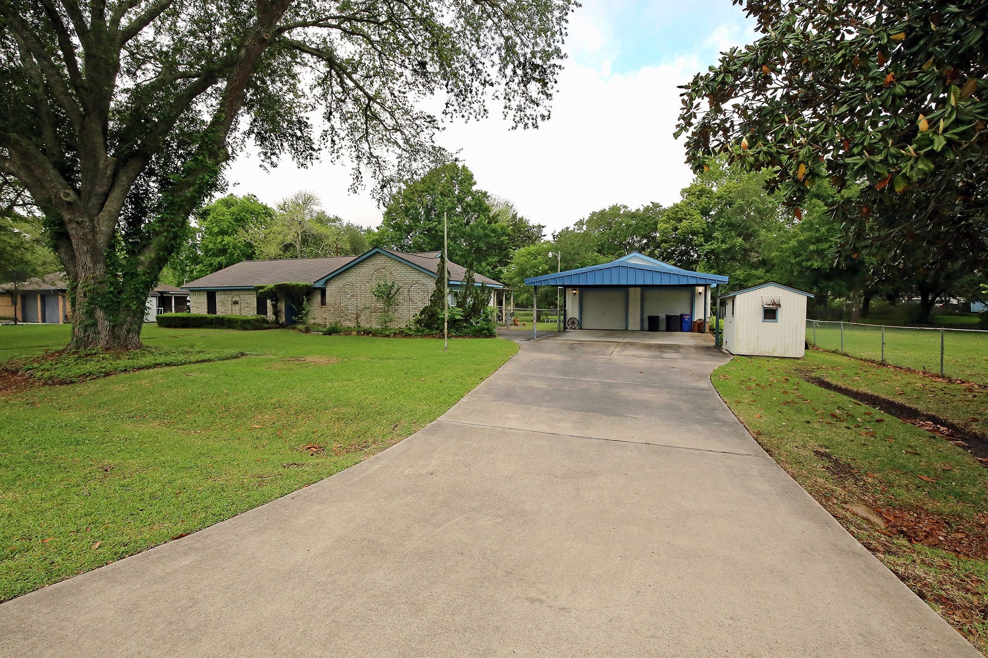3804 Shady Lane, Santa Fe, TX 77517 A charming single-story brick home with a carport and detached garage.