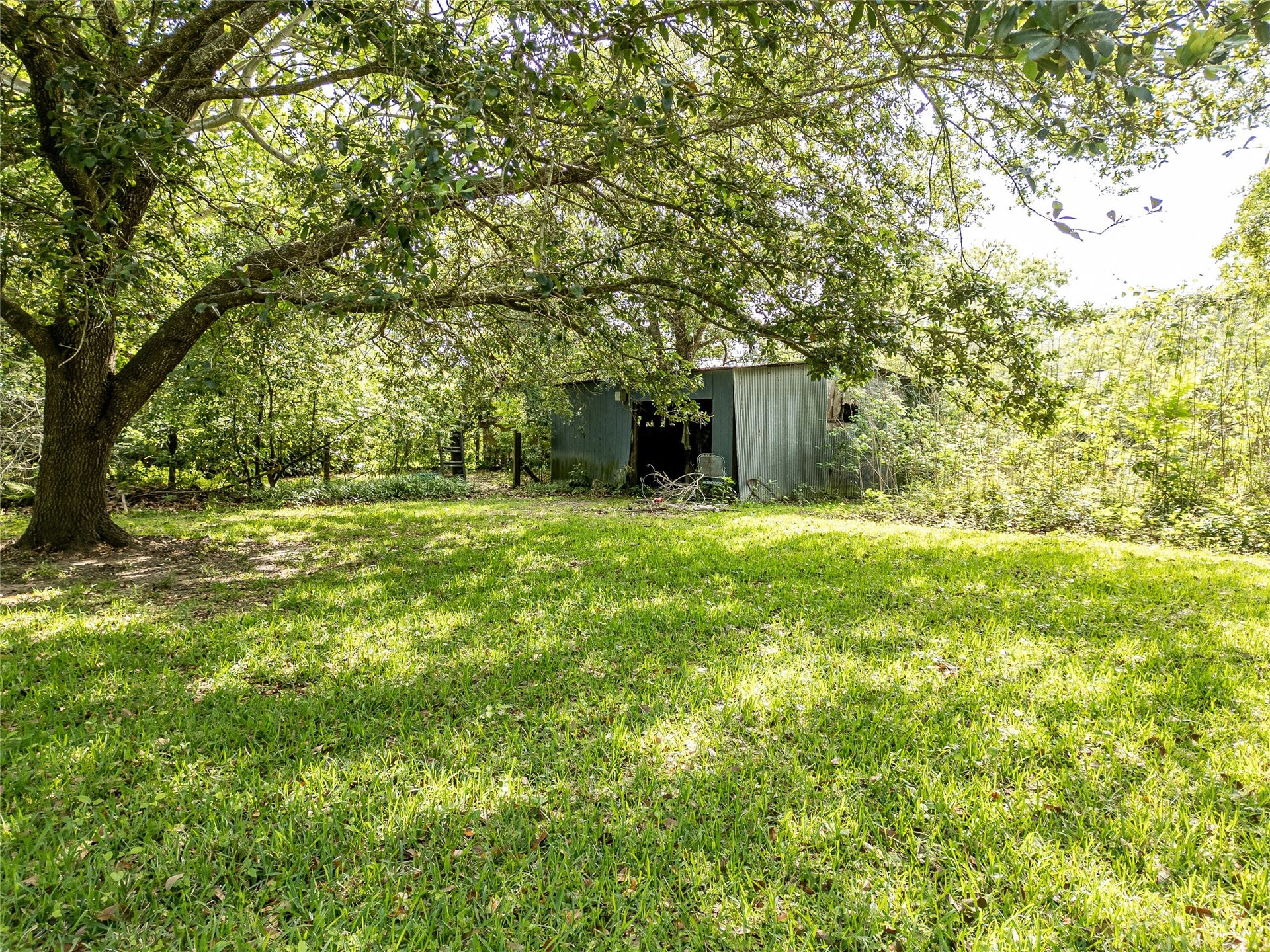 3804 Shady Lane, Santa Fe, TX 77517 A horse barn nestled in a serene, shaded setting.
