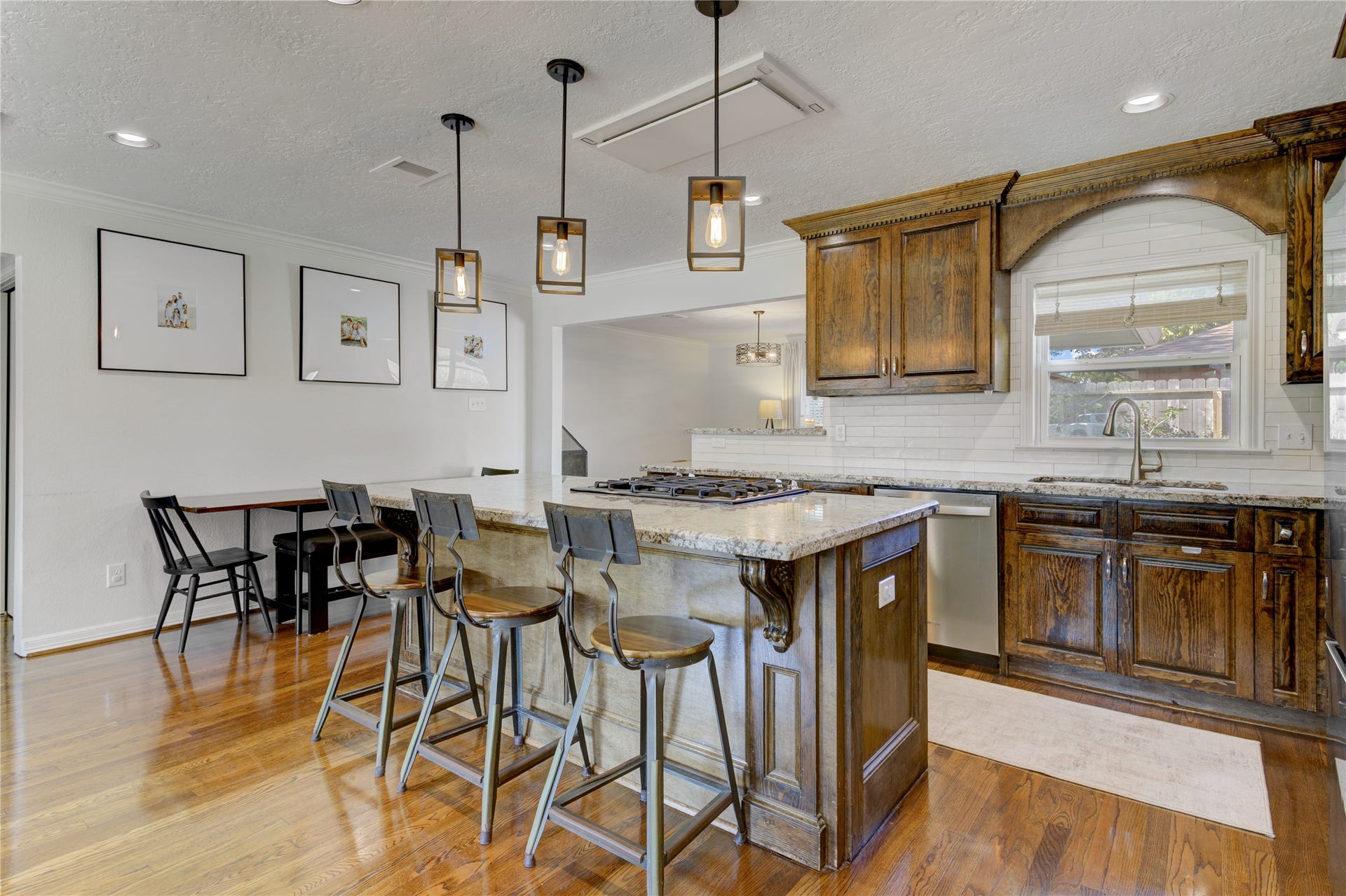3007 Topham Circle, Houston, TX 77018 The kitchen offers bartop seating at the island, stainless steel gas range, and low-profile ceiling vent hood.