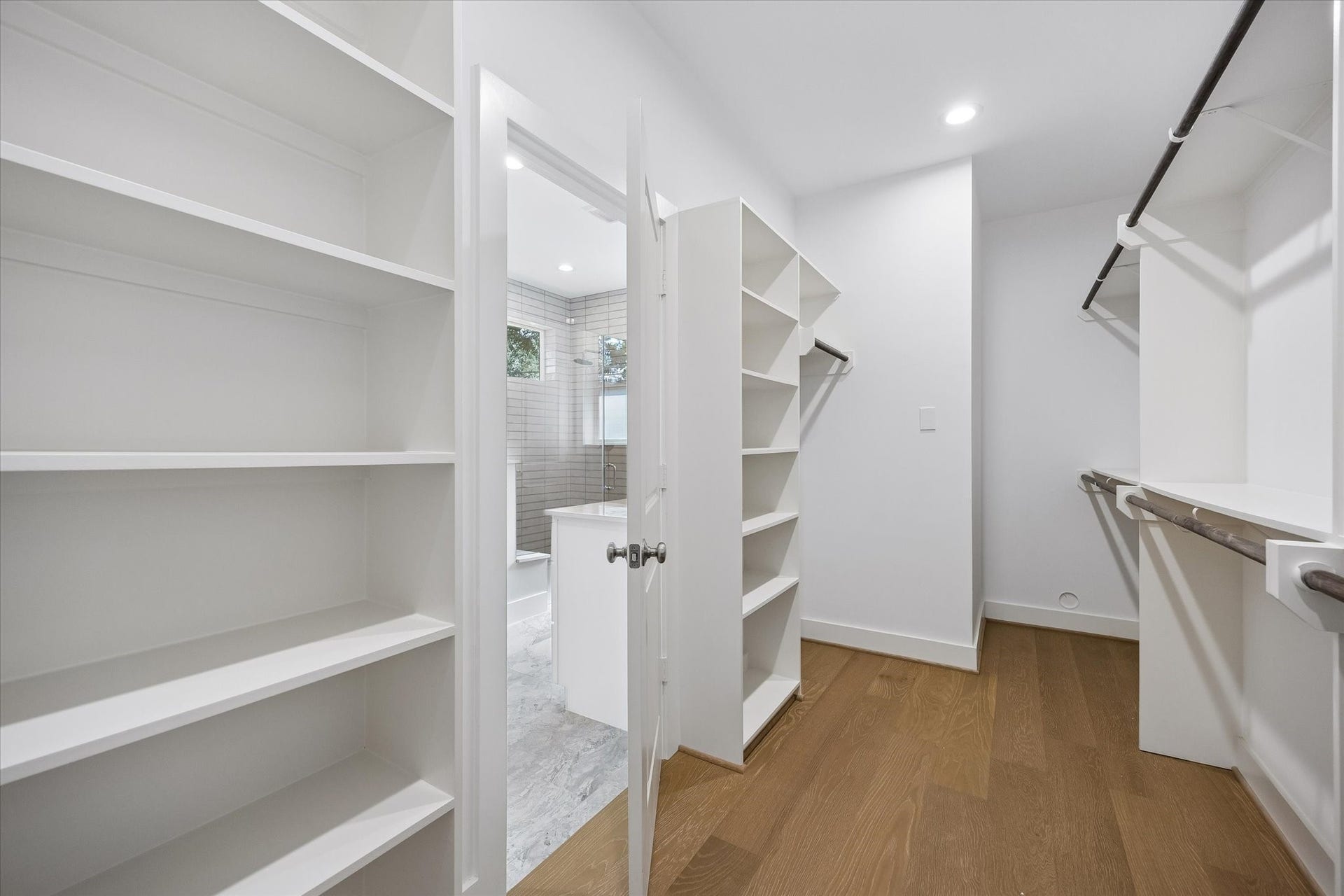 10659 Mayfield Road, Houston, TX 77043 The primary bedroom closet boasts ample storage with built-in shelving and extensive hanging space, ensuring organization is effortless. Its spacious design allows for easy access and arrangement of clothing and accessories.
