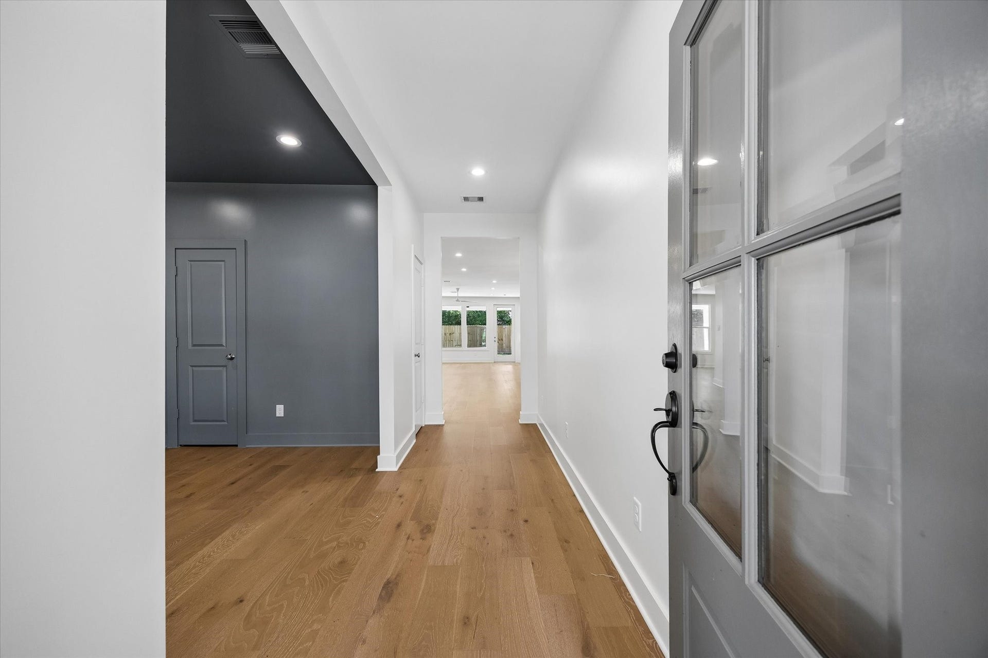 10659 Mayfield Road, Houston, TX 77043 Warm wood flooring draws the eye from the entry through the home, creating a clean sightline toward the main living areas and backyard beyond.